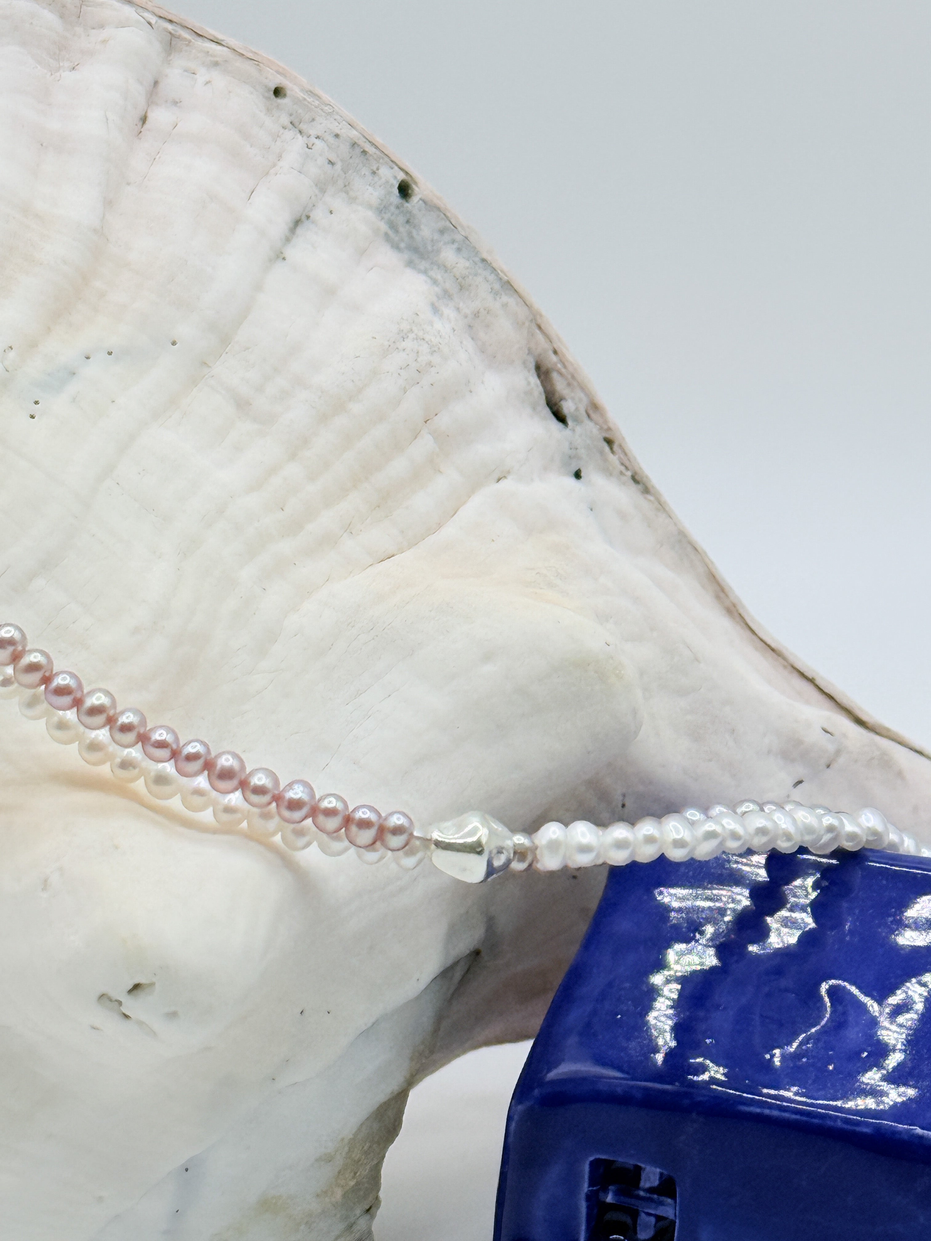 Close up details of the silver beads on the seed pearl strand of the freshwater twin strand necklace. 