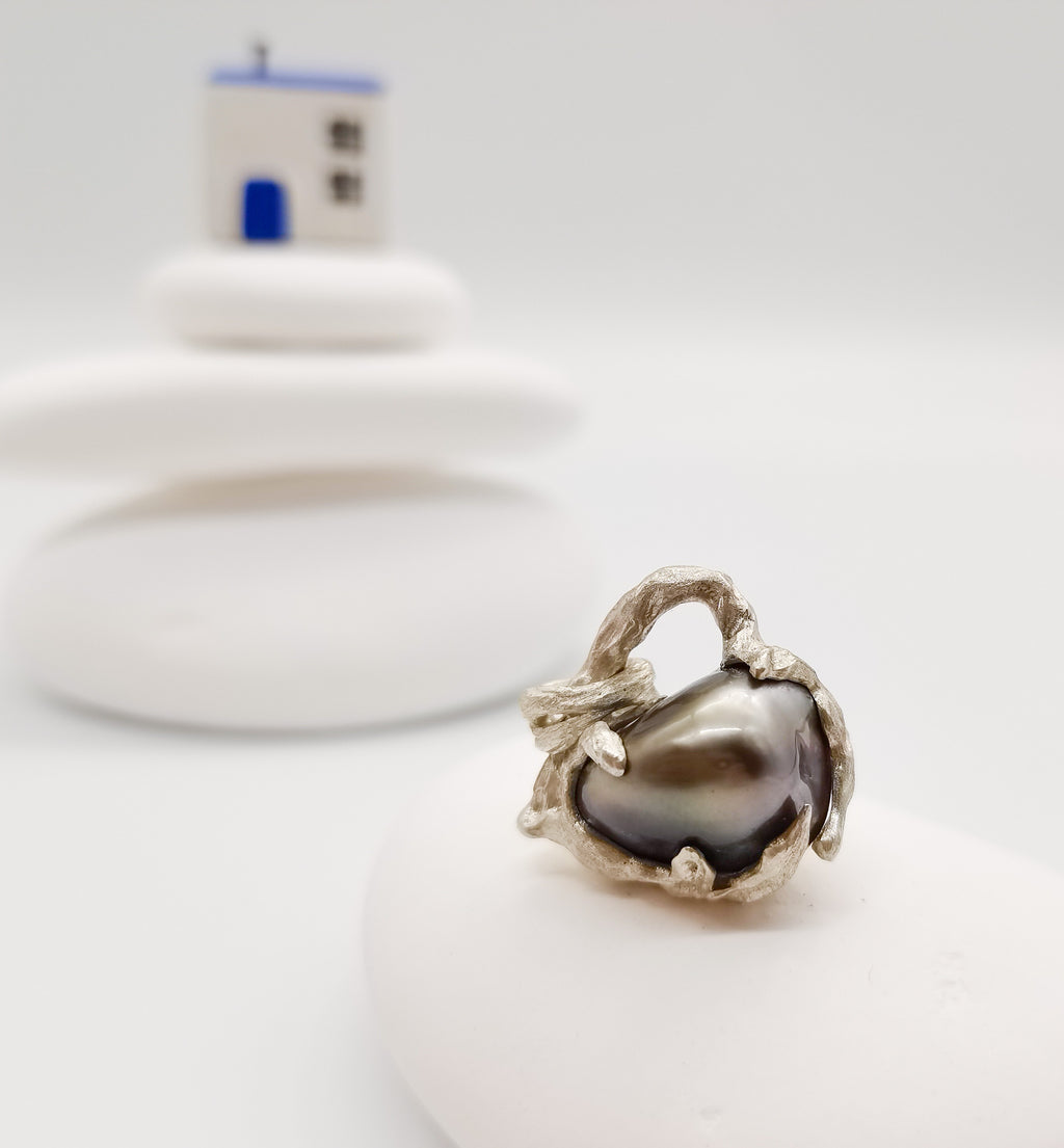 The beautiful heart pendant sit in the fore ground with a little house in the soft focused background 