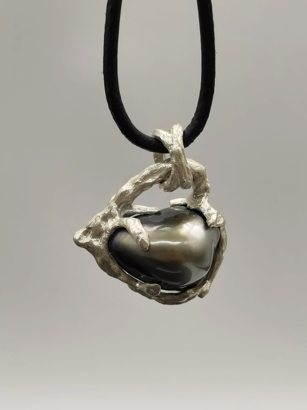 TAHITIAN PEARL HEART PENDANT attached to a black cord to show of the modern and unique style of the jewellery