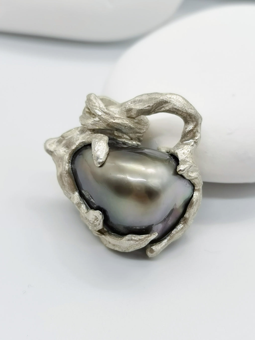 Details of the Tahitian pearl heart pendant's intricate silver work and high lustre of the pearl giving out high reflection