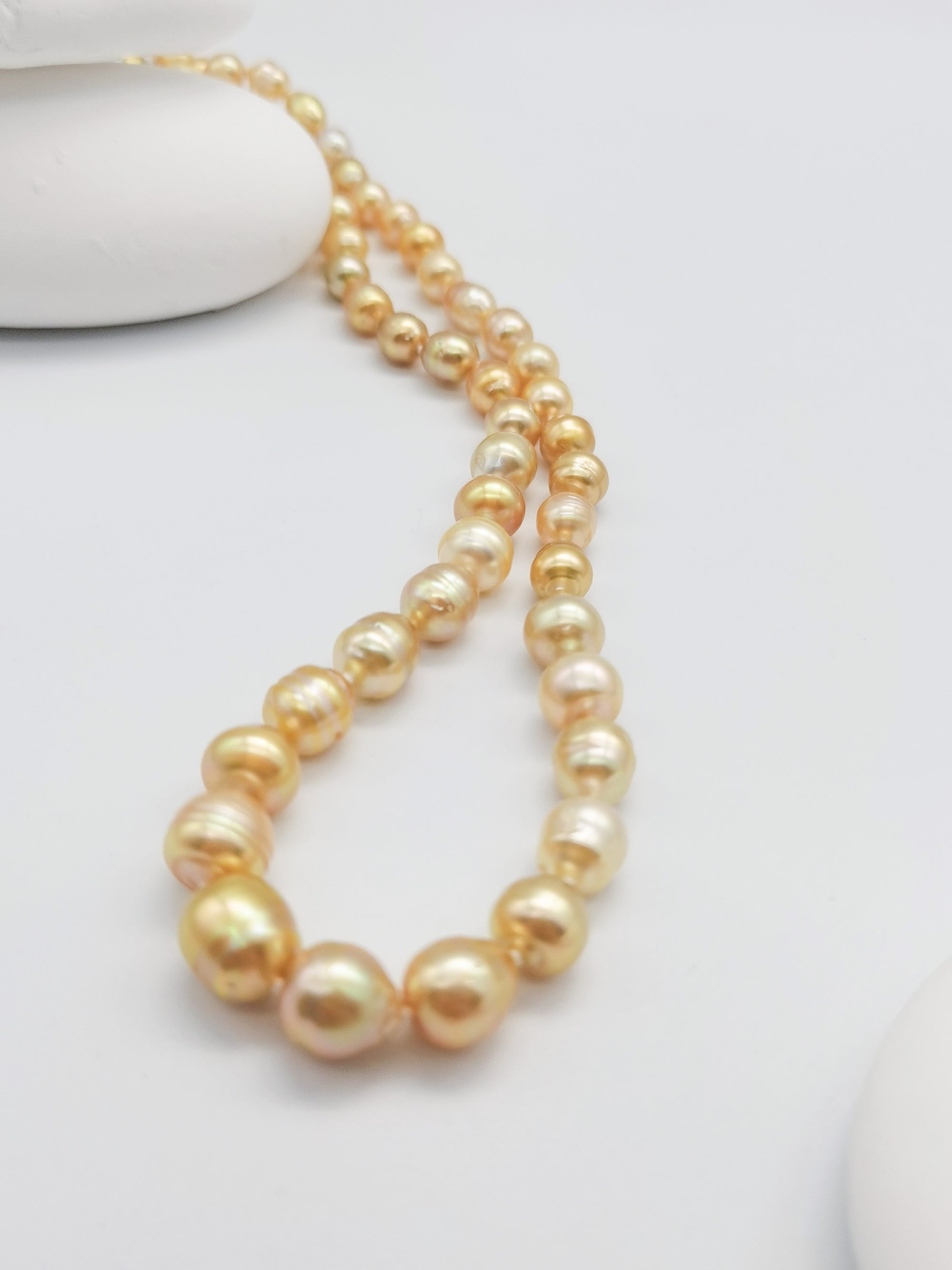 Full-length golden baroque pearl strand necklace with gold clasp, showcasing the complete graduated design from smaller to larger pearls in rich golden hues
