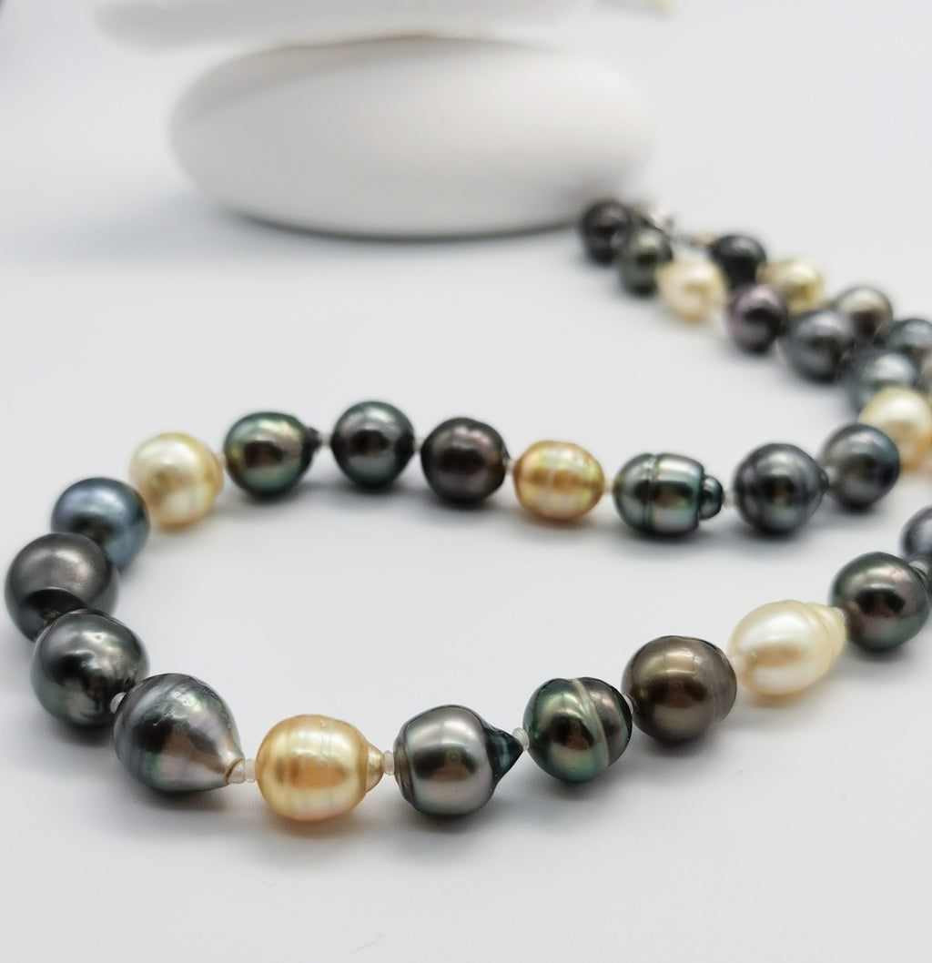 Multicoloured baroque pearl necklace with dark green, black, golden and white pearls in close-up detail, showcasing the lustrous variety of natural pearl colours and shapes