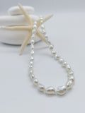 South Sea white keshi pearl strand necklace elegantly styled with starfish and white stones background