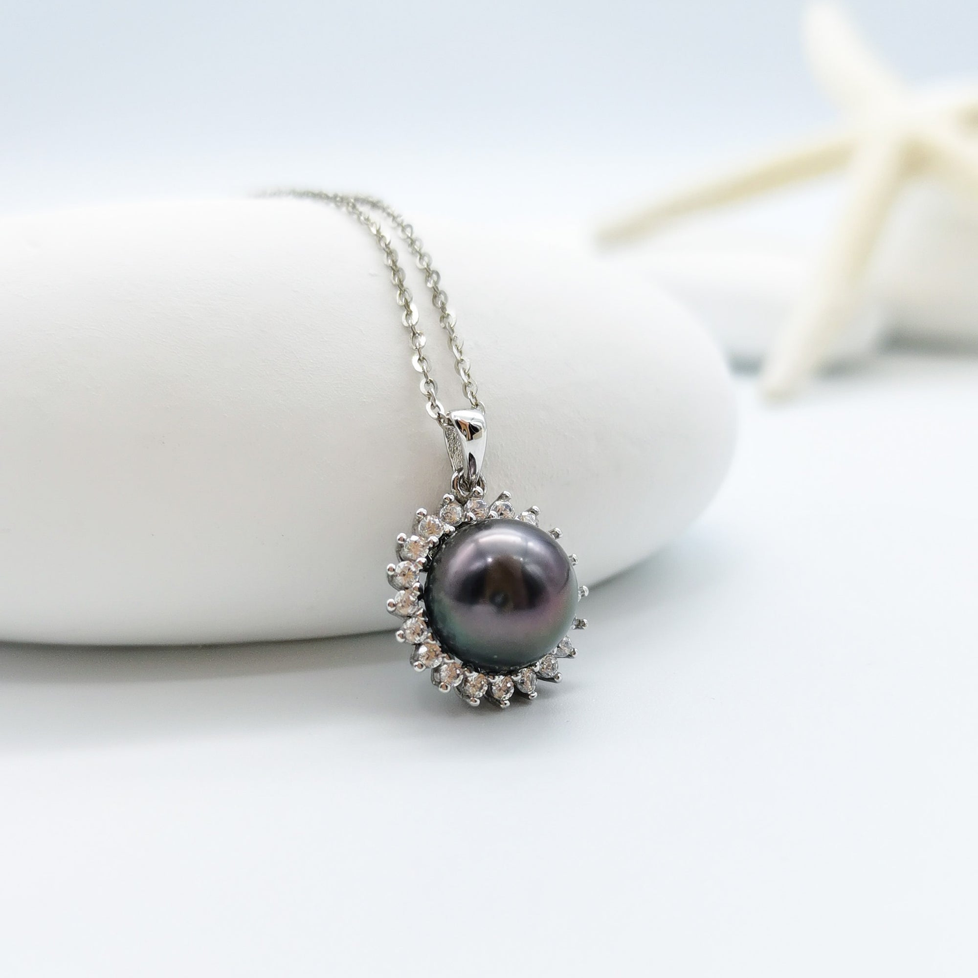 Tahitian pearl pendant necklace 10mm round pearl CZ halo 925 sterling silver sunburst mount showing peacock undertones