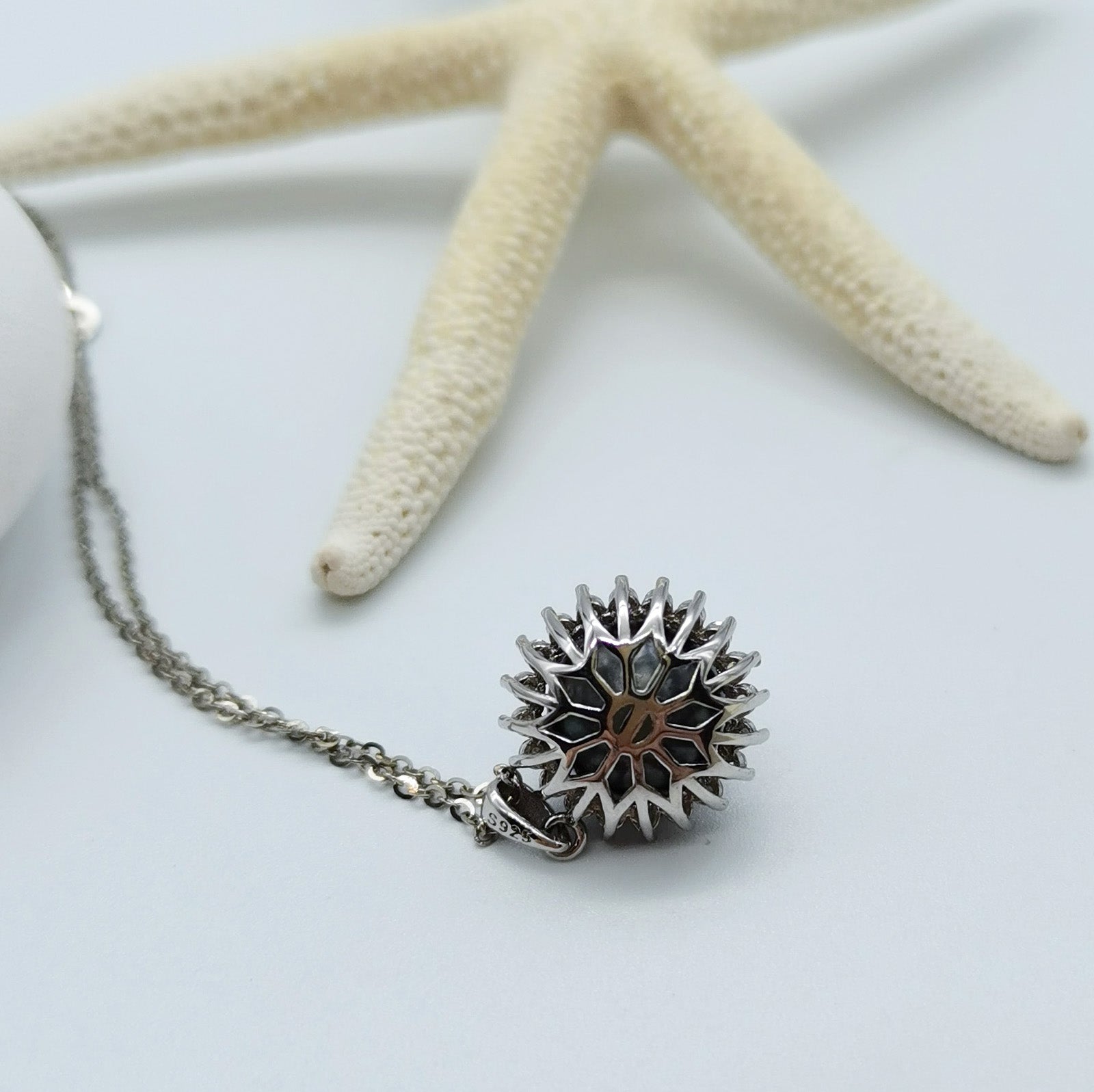 Tahitian pearl pendant necklace back view showing intricate sunburst openwork design 925 sterling silver mount starfish styling