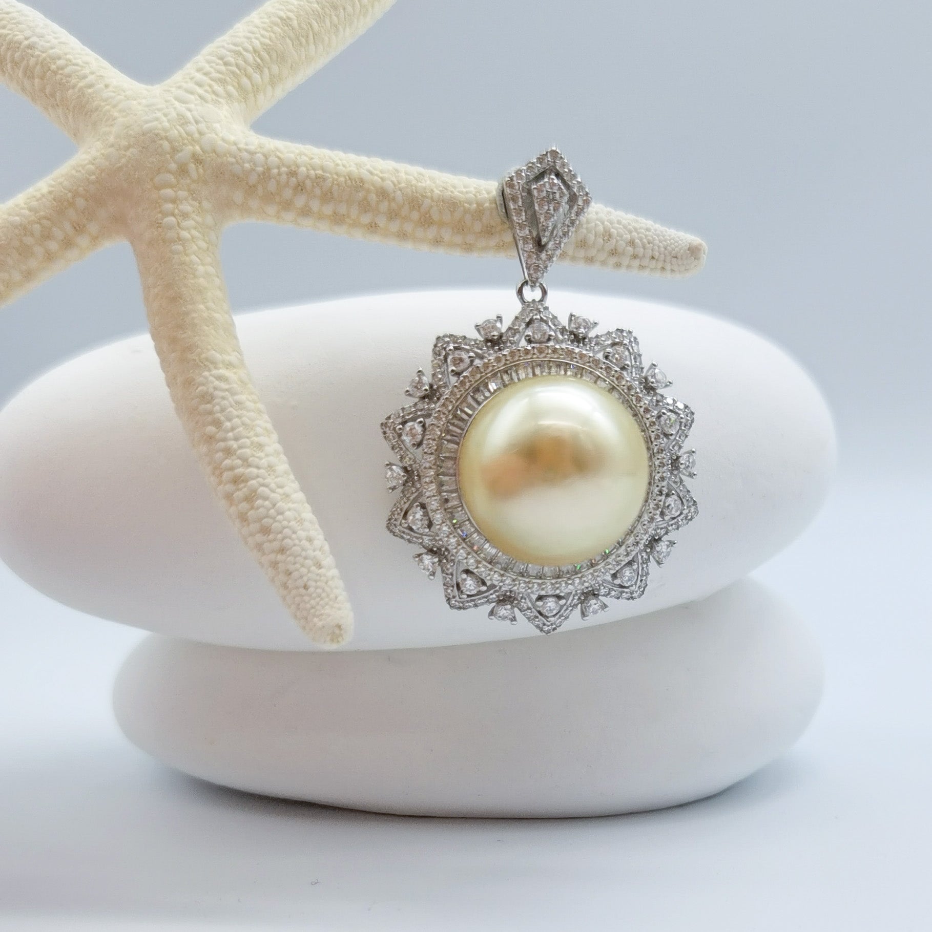 Gold South Sea pearl pendant showing CZ halo setting 925 sterling silver compass-back mount starfish styling oceanic display