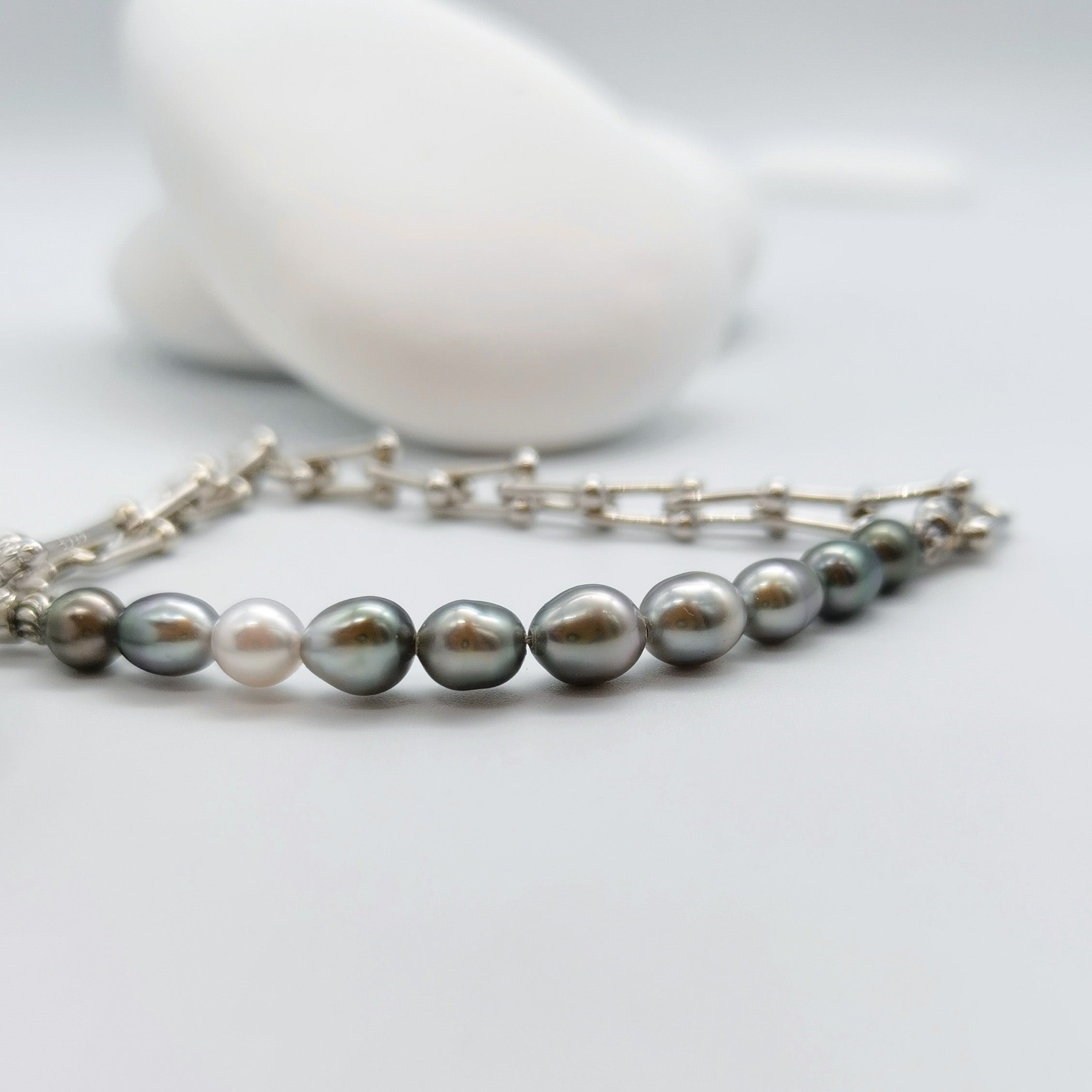 Tahitian keshi pearl chain bracelet with green iridescent pearls and white South Sea pearl accent on sterling silver horseshoe gauge links