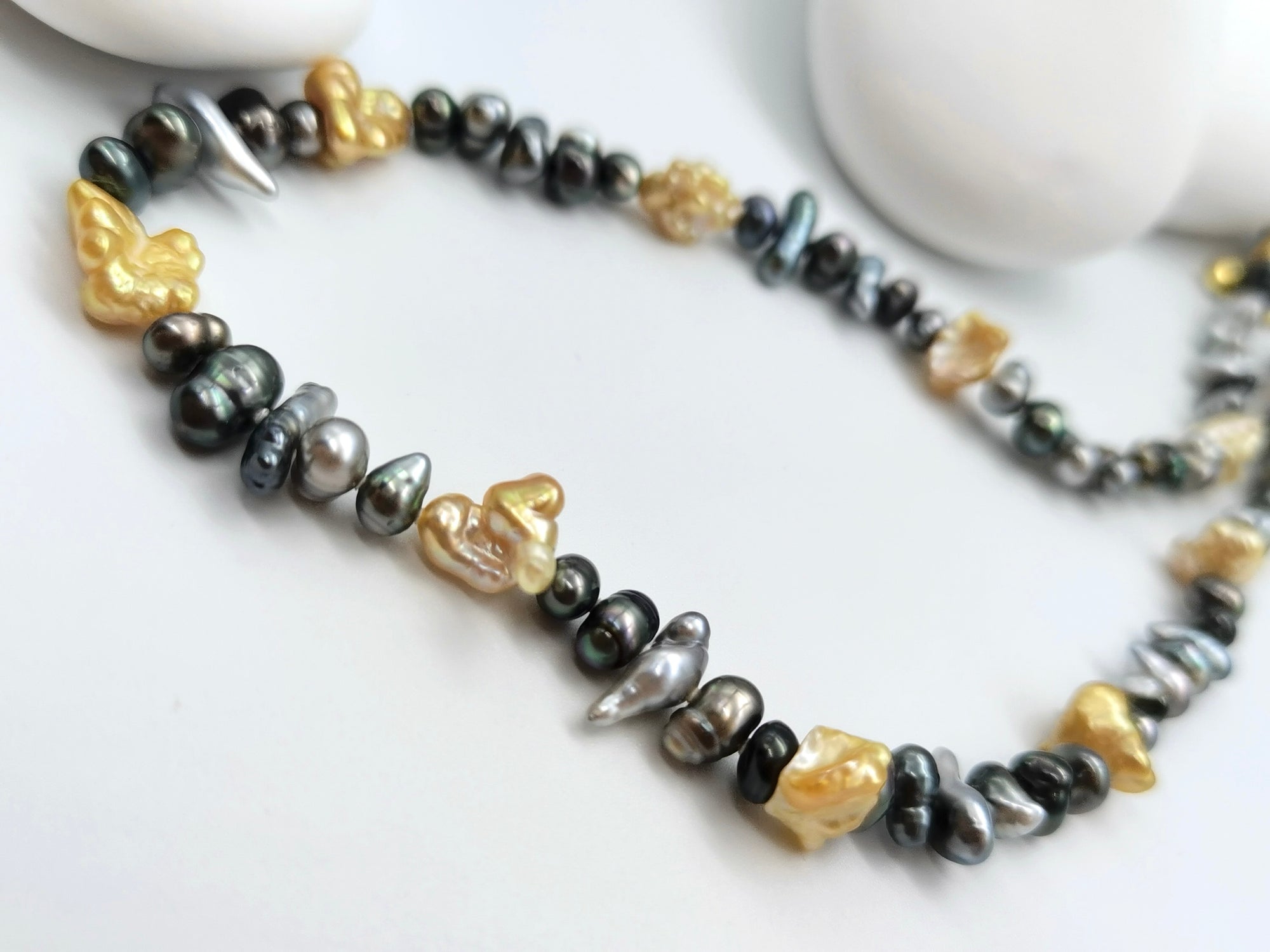 Tahitian and gold South Sea keshi pearl necklace showing various colour Tahitian pearls with irregular shapes and gold pearl spacers
