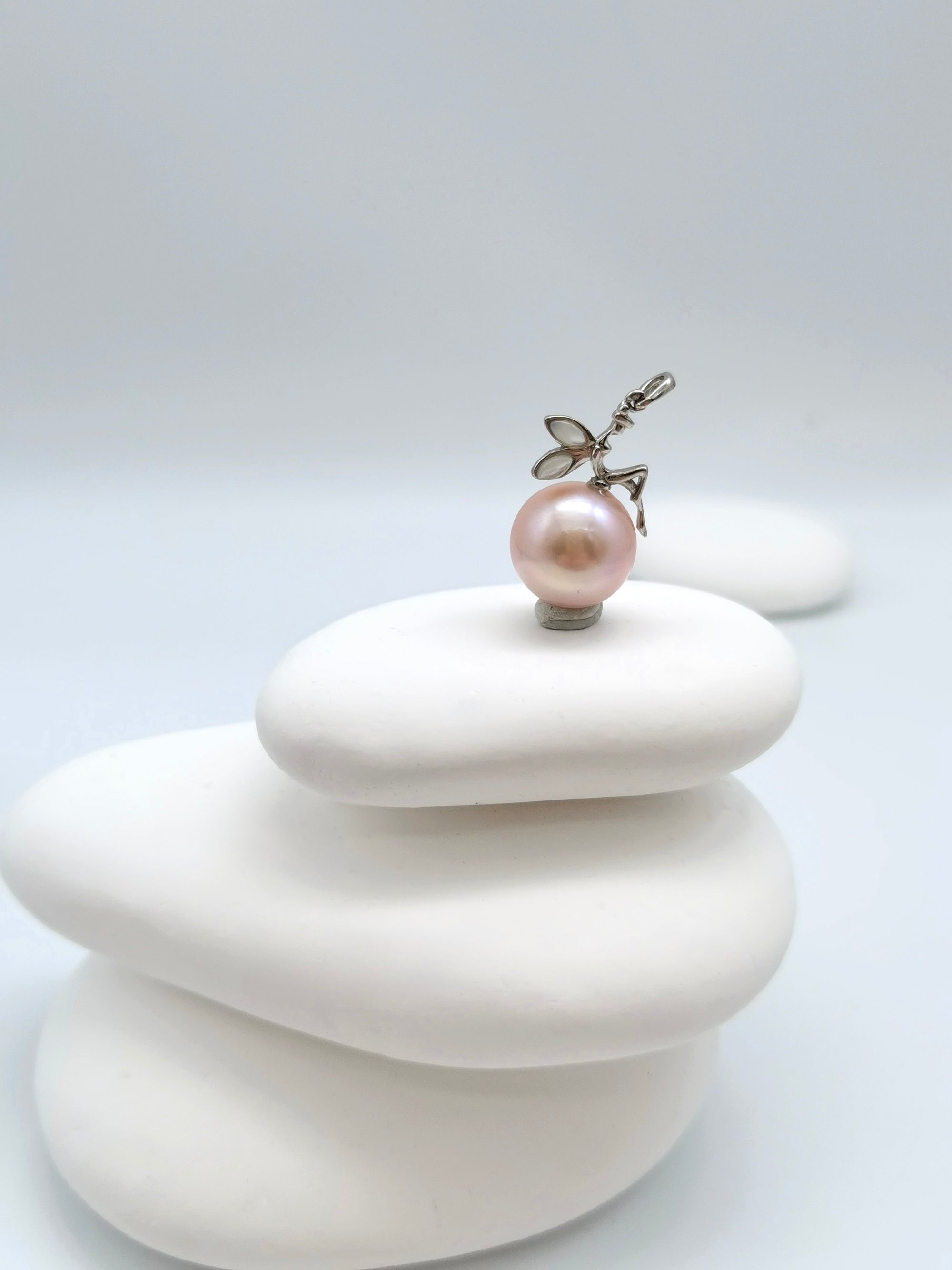 Side view of pink freshwater pearl fairy pendant displaying fairy wings and 12mm round pearl proportions