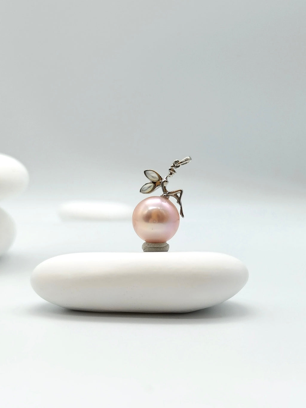 Close-up of sterling silver fairy detail on pink freshwater pearl pendant showing intricate craftsmanship and pearl lustre