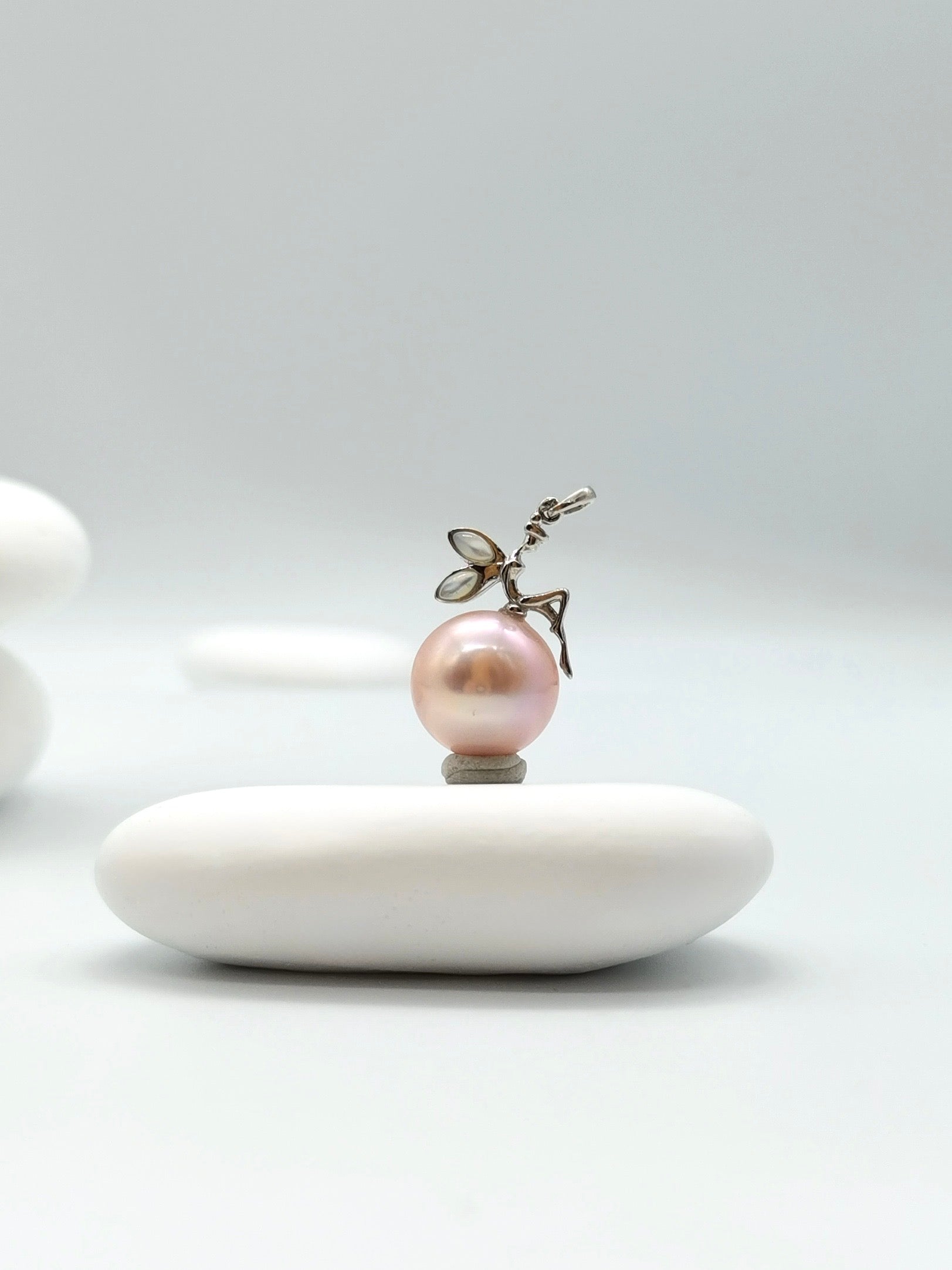 Close-up of sterling silver fairy detail on pink freshwater pearl pendant showing intricate craftsmanship and pearl lustre