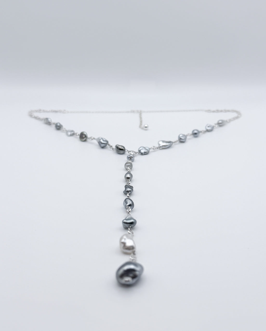 Y-shaped Tahitian Keshi pearl necklace with CZ accents displayed in full view on white background