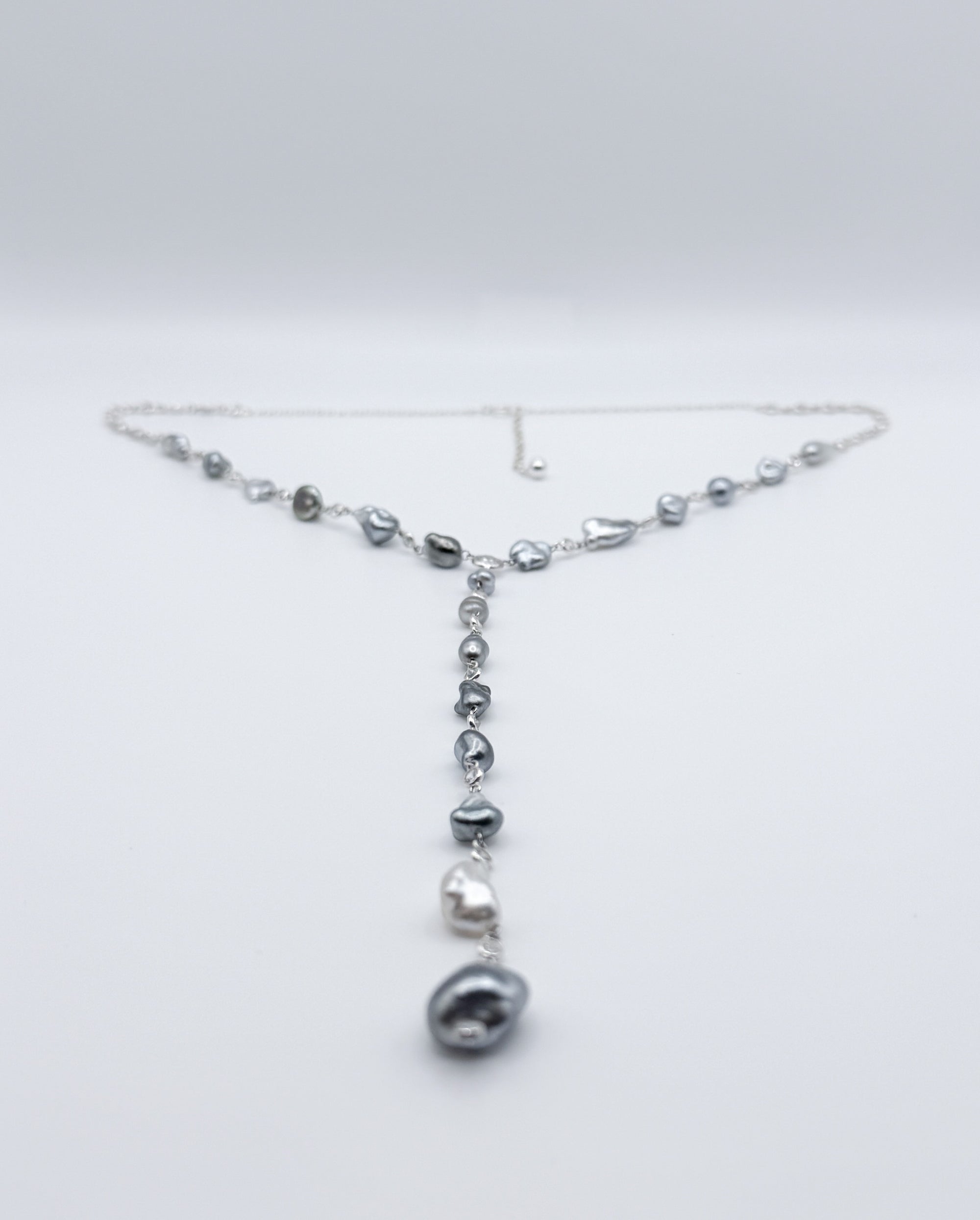 Y-shaped Tahitian Keshi pearl necklace with CZ accents displayed in full view on white background