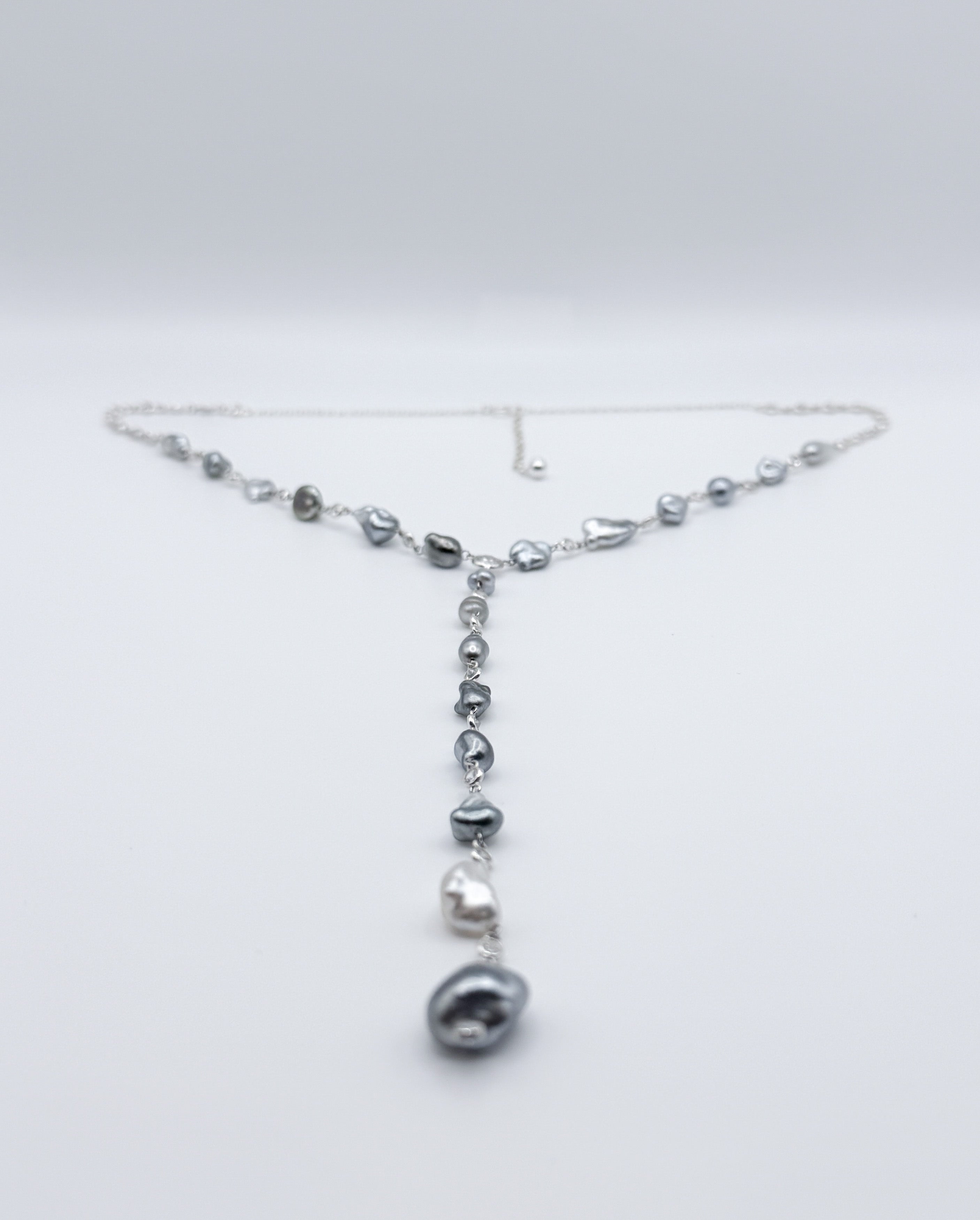Y-shaped Tahitian Keshi pearl necklace with CZ accents displayed in full view on white background
