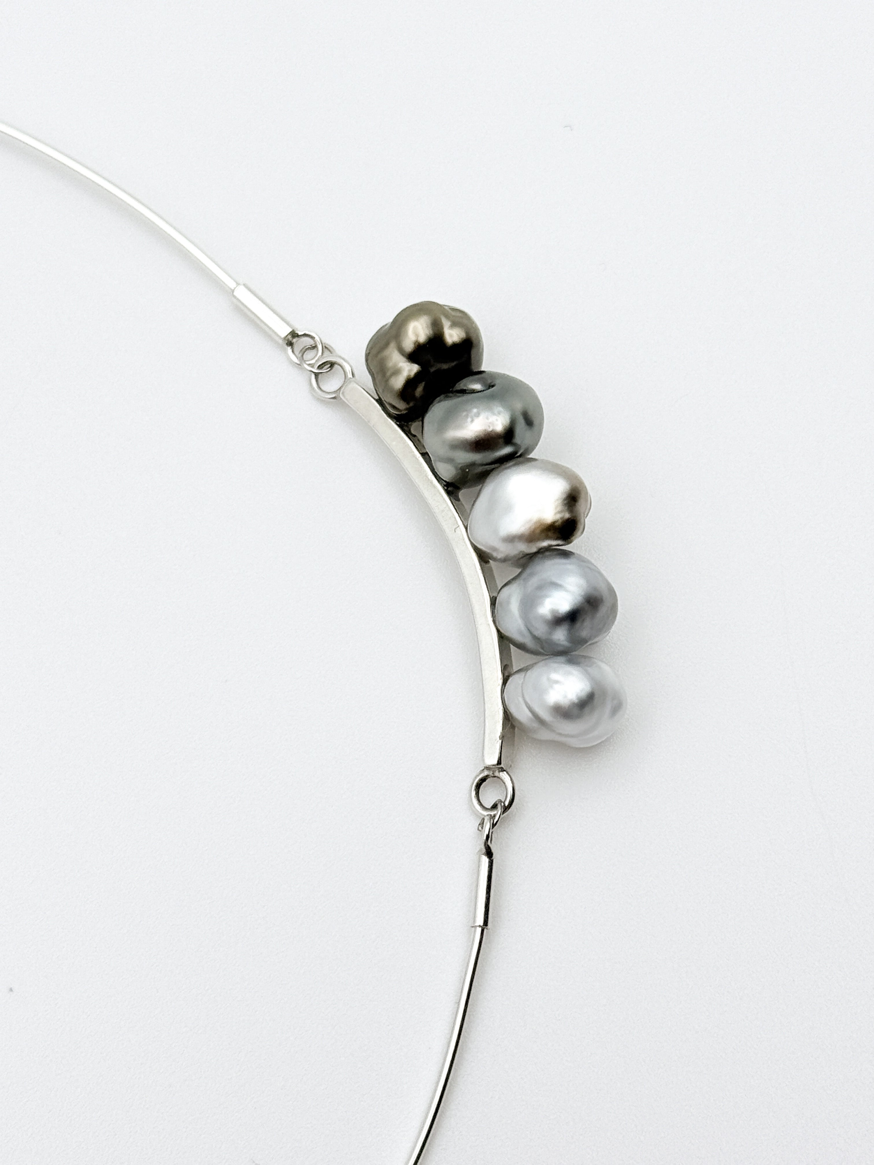 Close-up of Keshi pearls showing silver to bronze gradient and baroque shapes