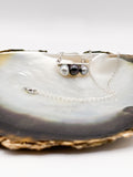 Close-up of three baroque pearls showing silver, green, and peacock overtones