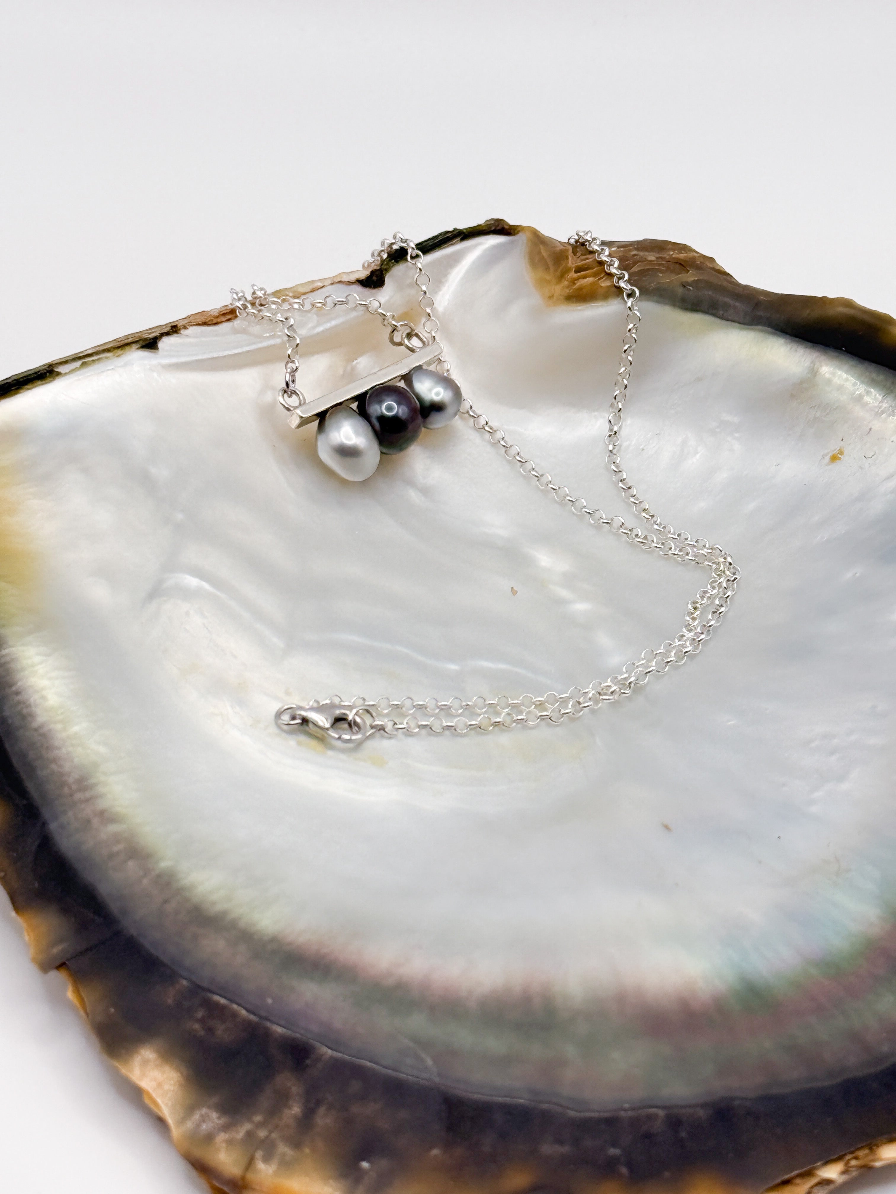 Side view highlighting 925 sterling silver bar setting and pearl spacing