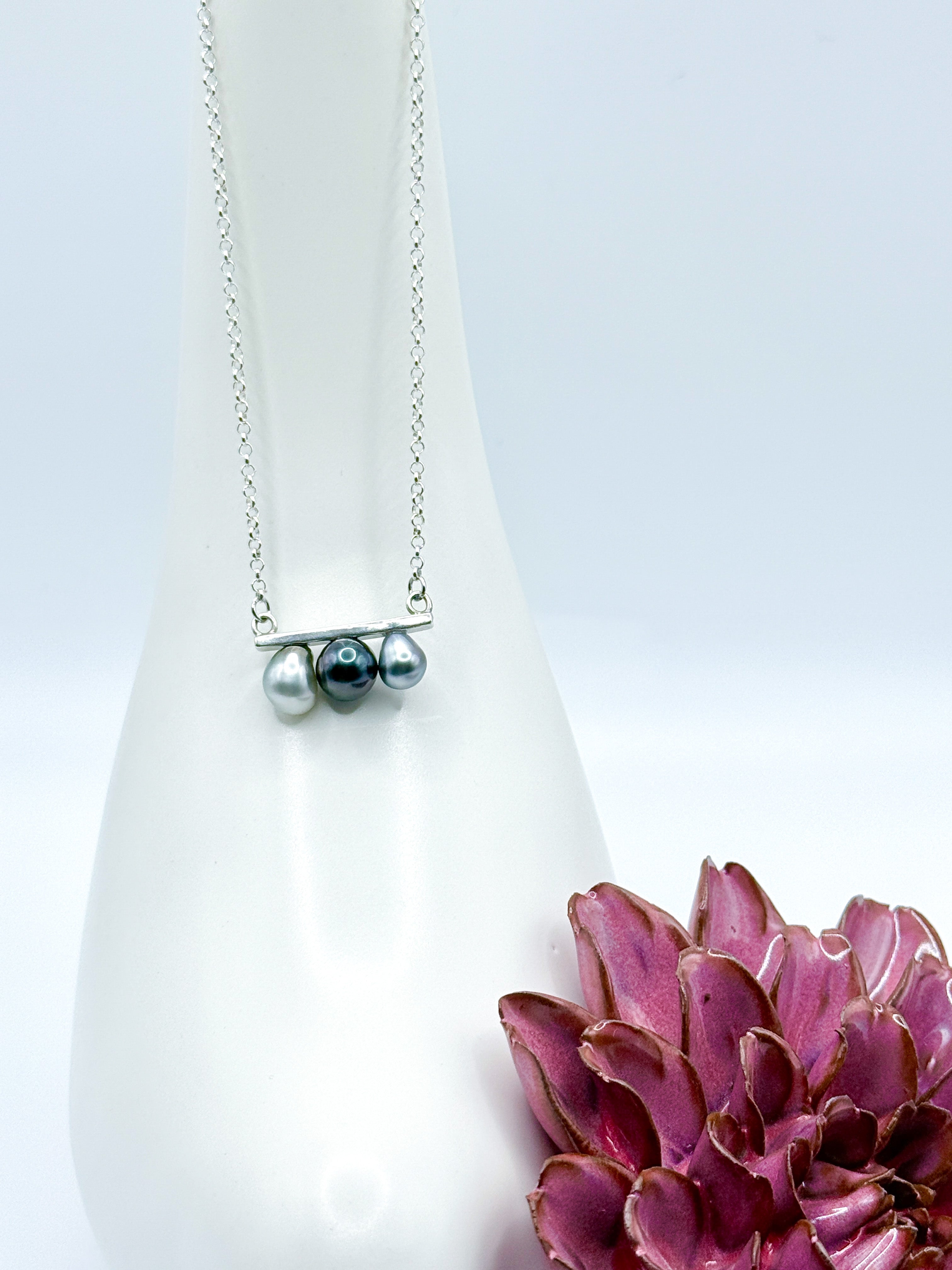 necklace hanging against a white background