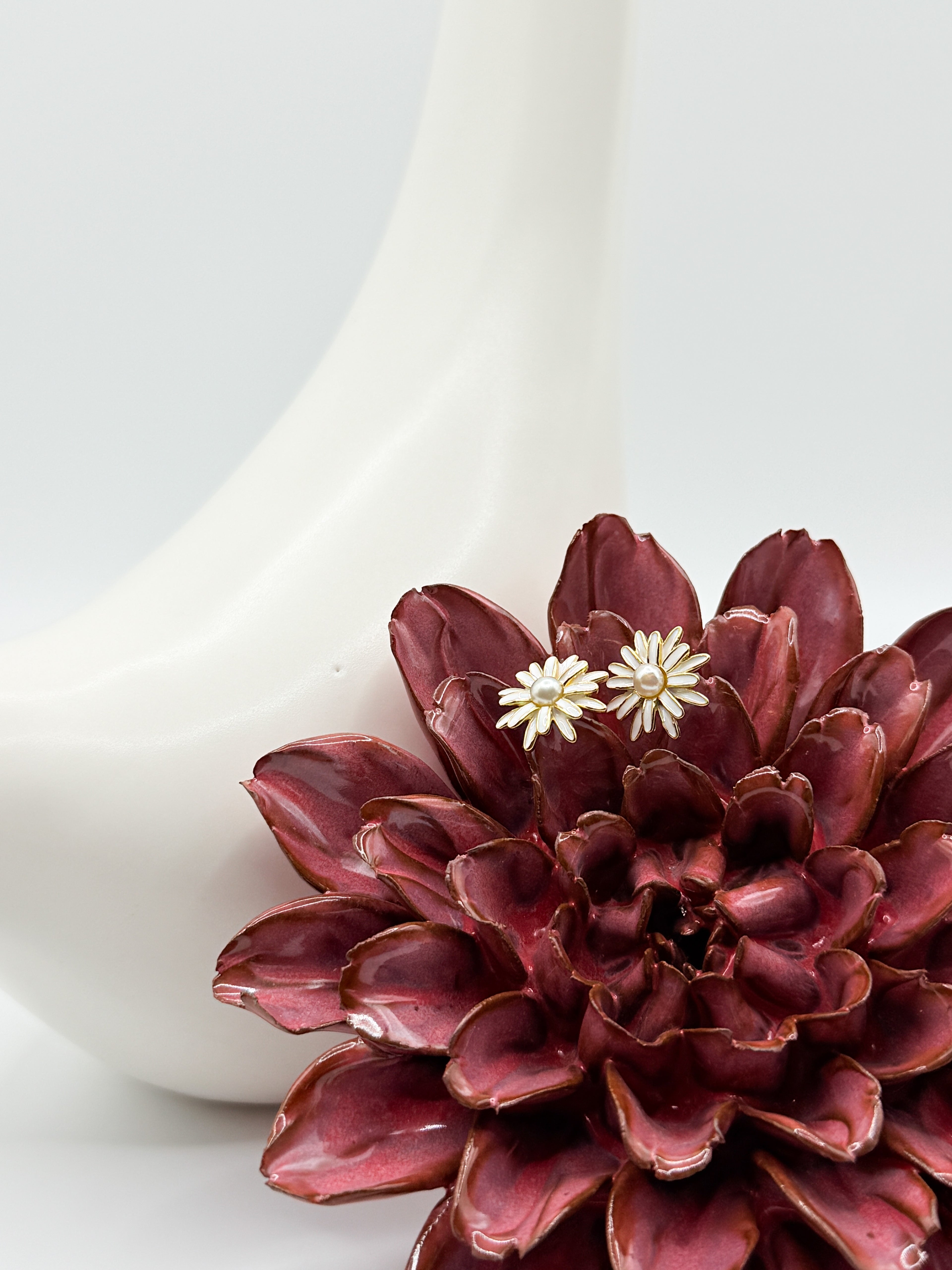 Close-up of white daisy earrings featuring central Keshi pearls with soft iridescence and petal detailing