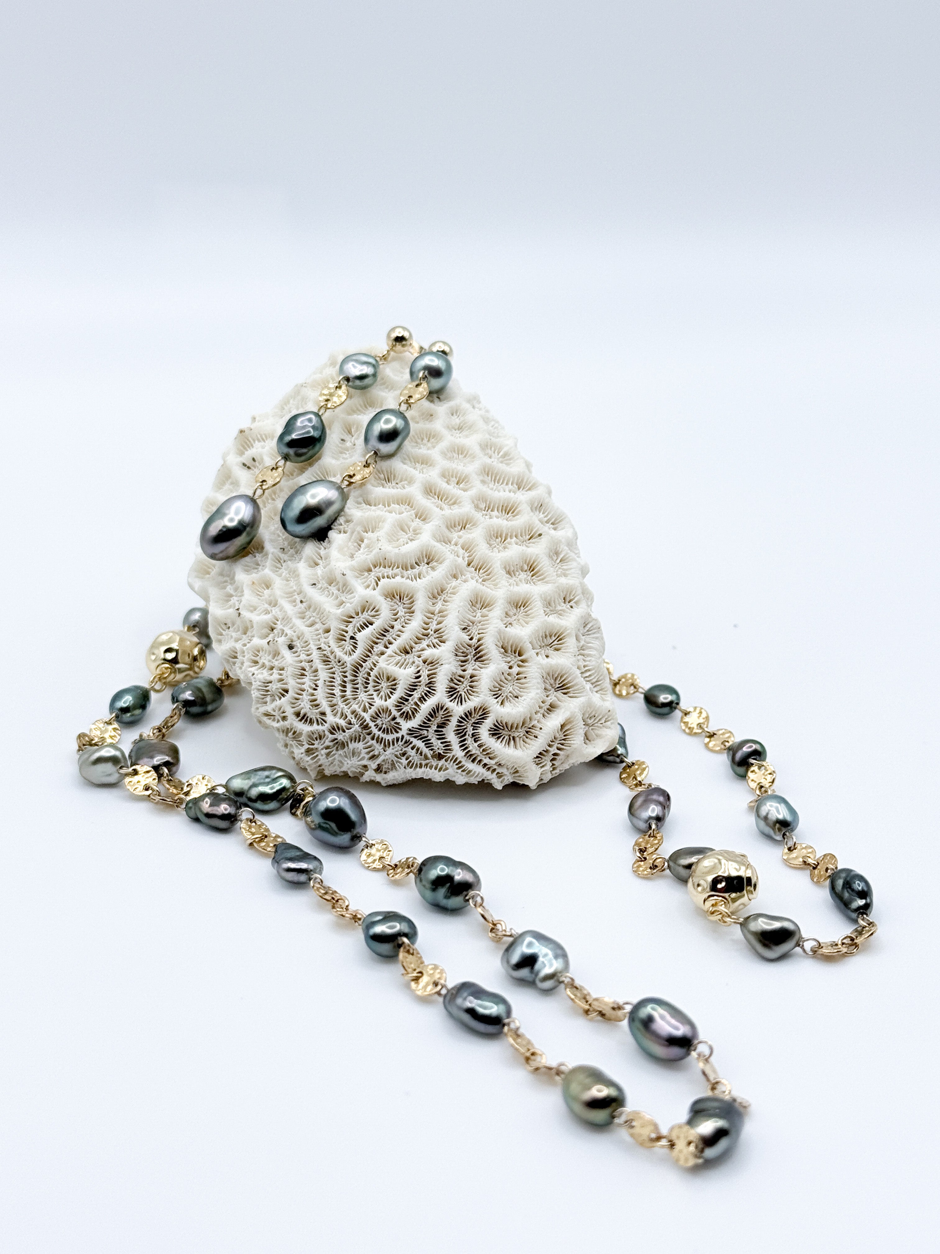 Close-up of necklace and earrings on coral prop 