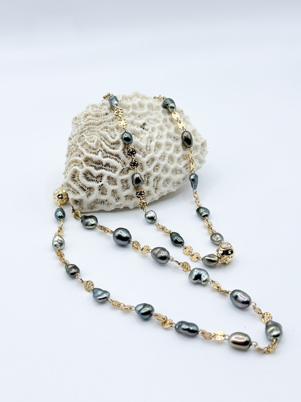 Bracelet and necklace arranged on coral prop highlighting Keshi pearl shapes and gold connectors