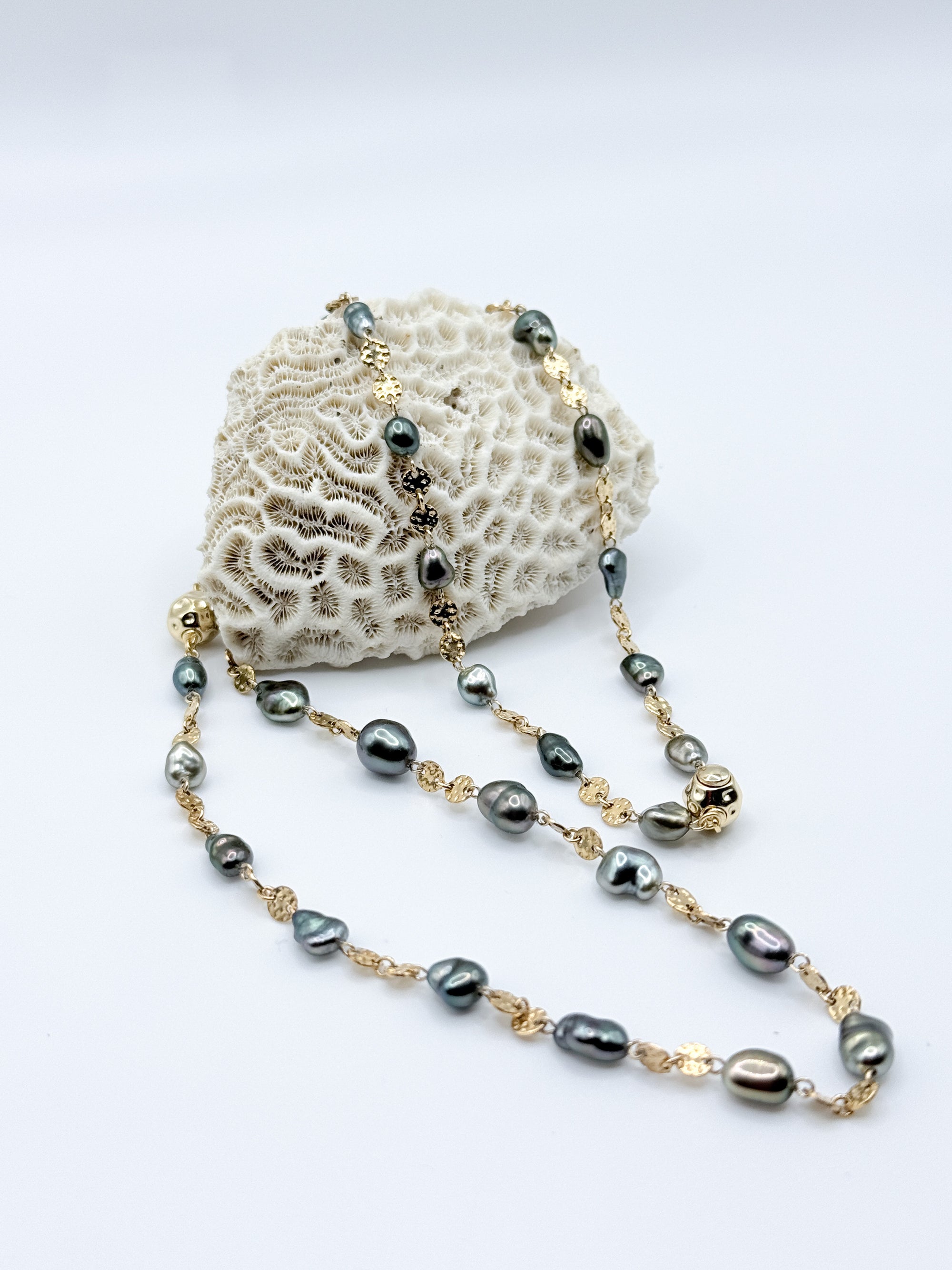 Bracelet and necklace arranged on coral prop highlighting Keshi pearl shapes and gold connectors