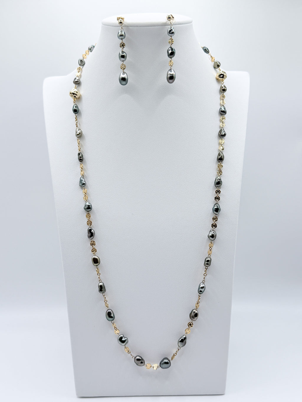 Alternate full display of necklace and earrings styled on white bust with balanced composition