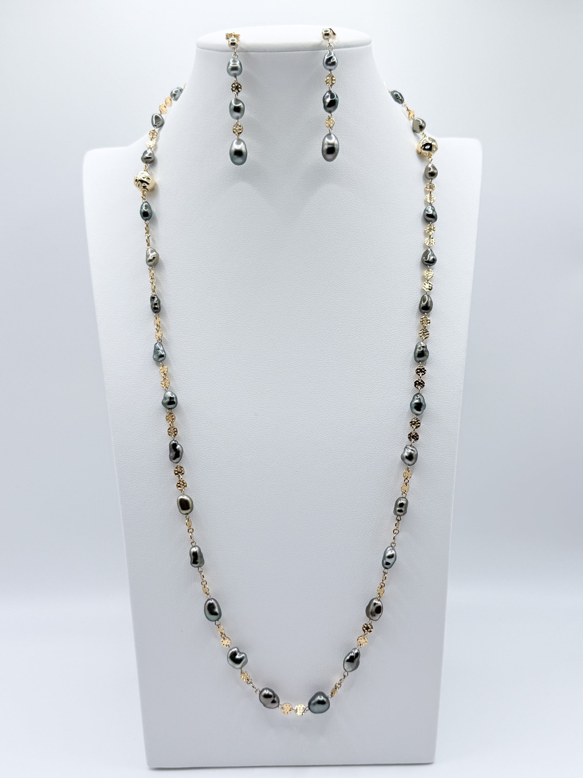 Alternate full display of necklace and earrings styled on white bust with balanced composition