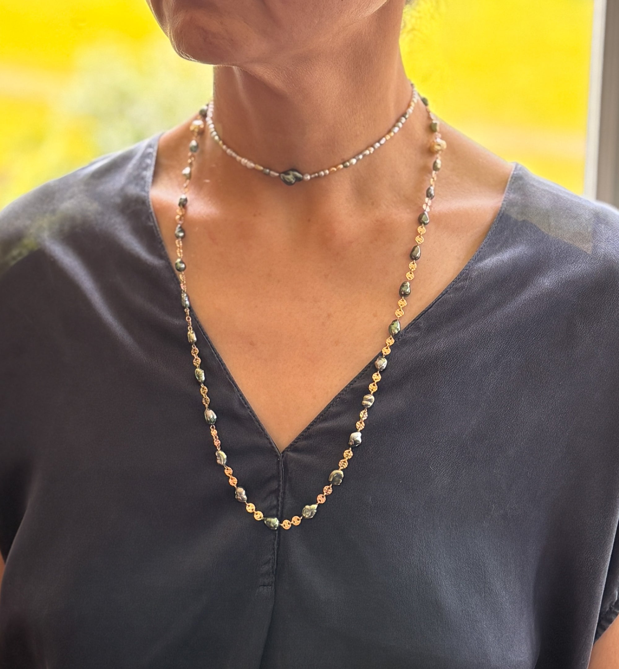 Model wearing full Tahitian pearl parure set with necklace styled long and choker layered above