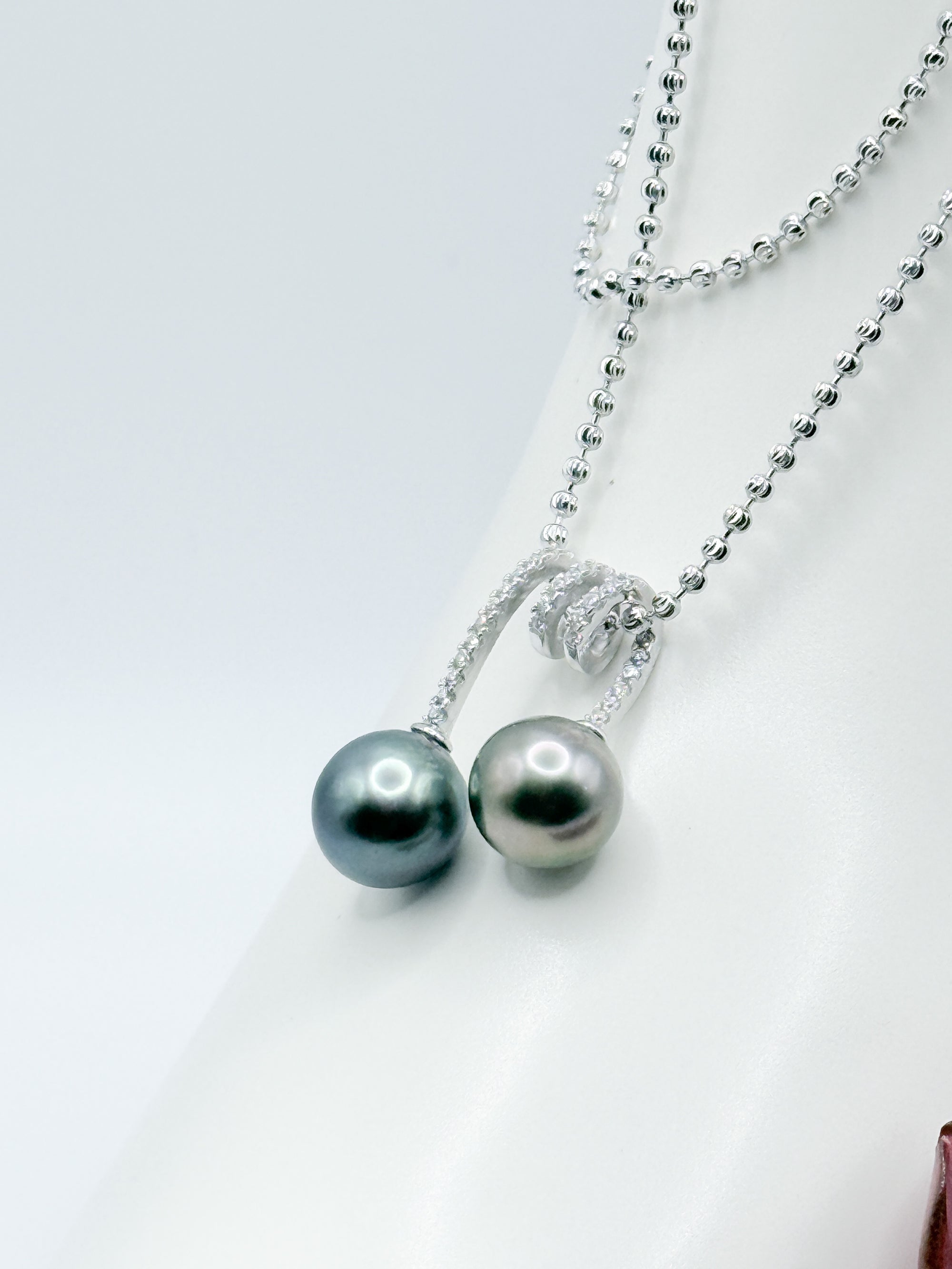 Close-up of double Tahitian baroque pearl pendant with CZ accents on a 925 sterling silver ball chain.