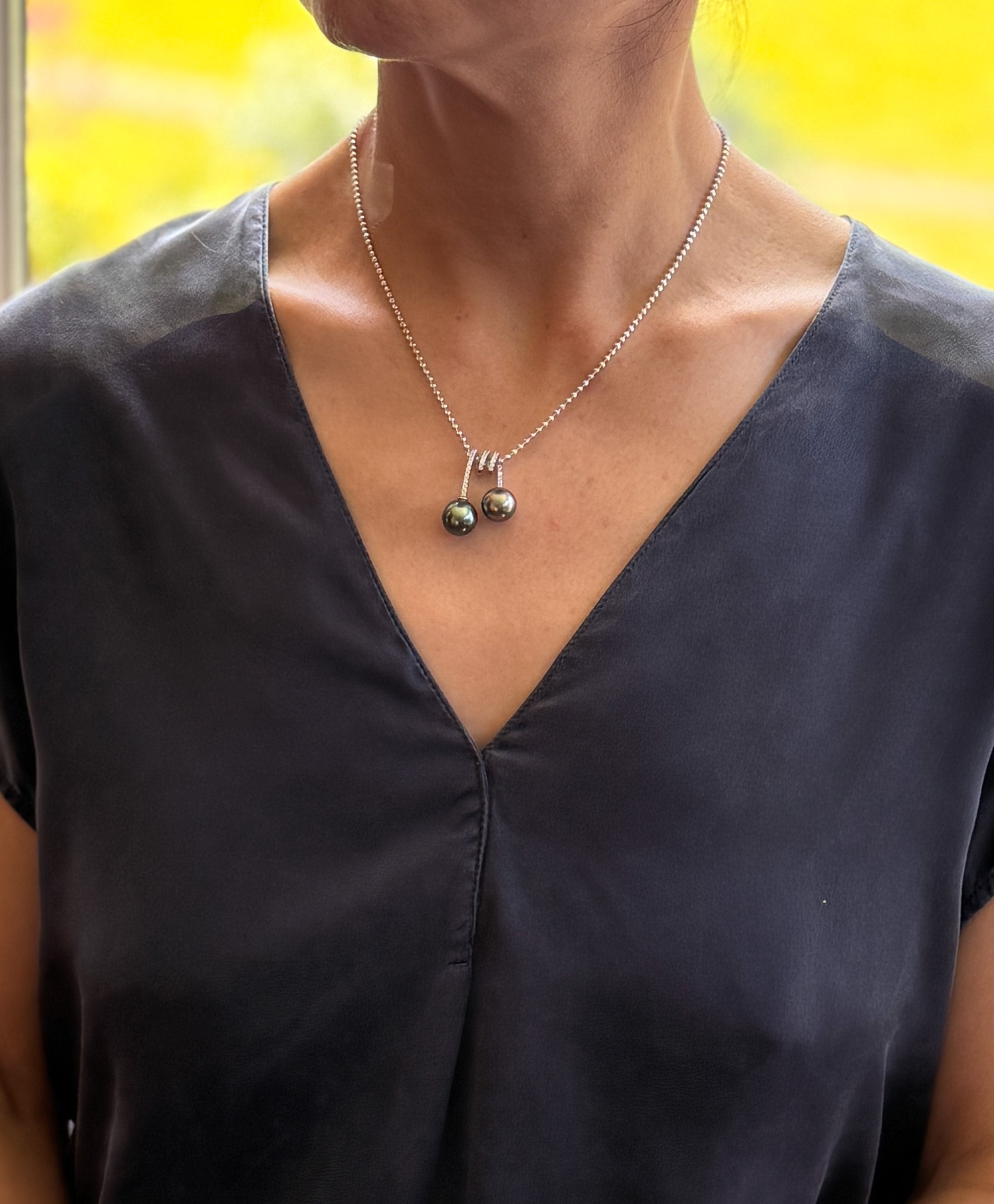 Model wearing double Tahitian pearl necklace with CZ setting and 925 silver ball chain.