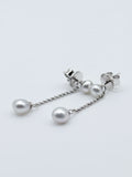 Close-up detail of sterling silver convertible earrings with white South Sea keshi pearls, showing the removable chain drops attached to stud backs on white background