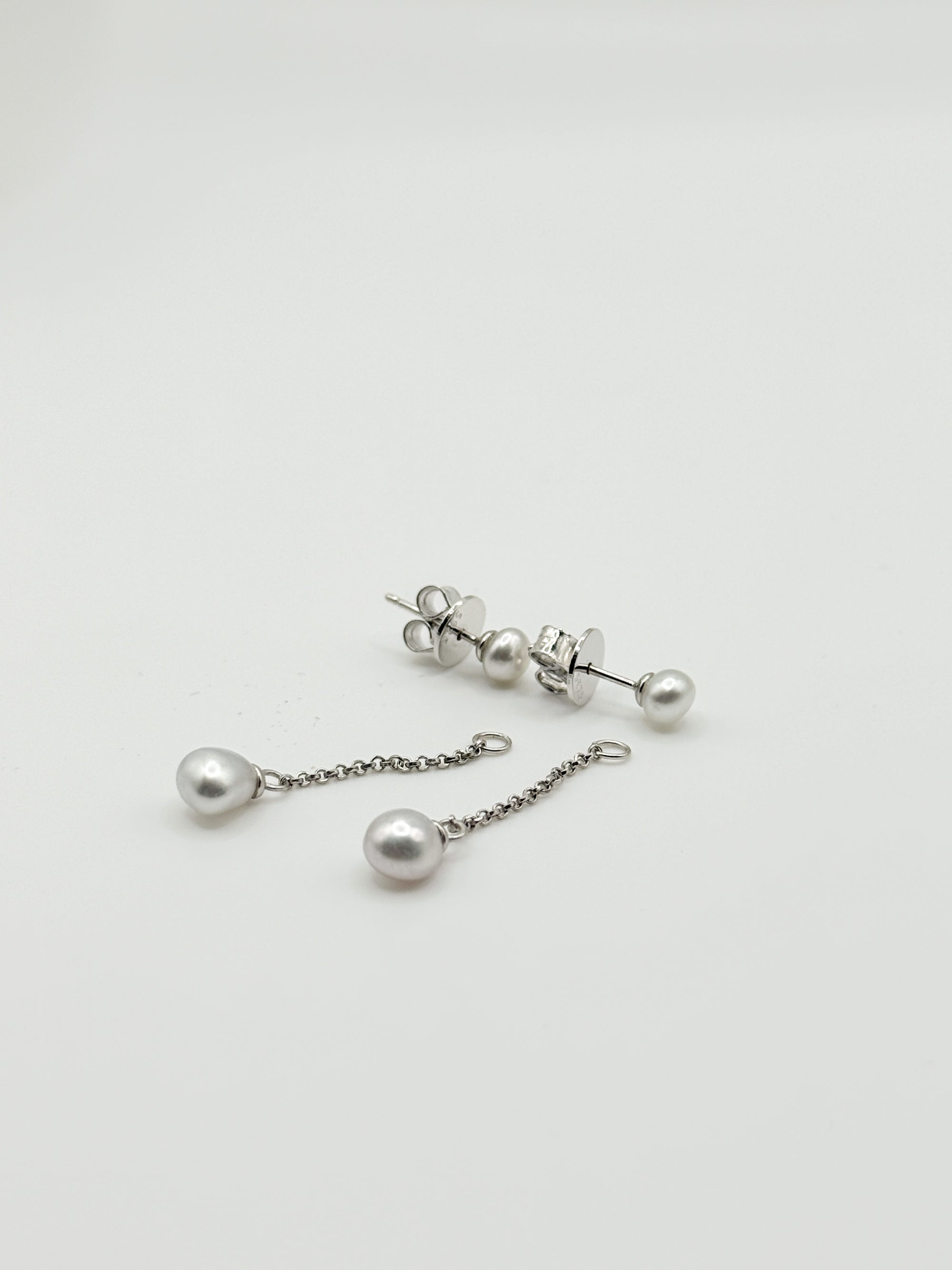 Sterling silver earrings with white South Sea keshi pearls showing both stud and drop chain styles on white background
