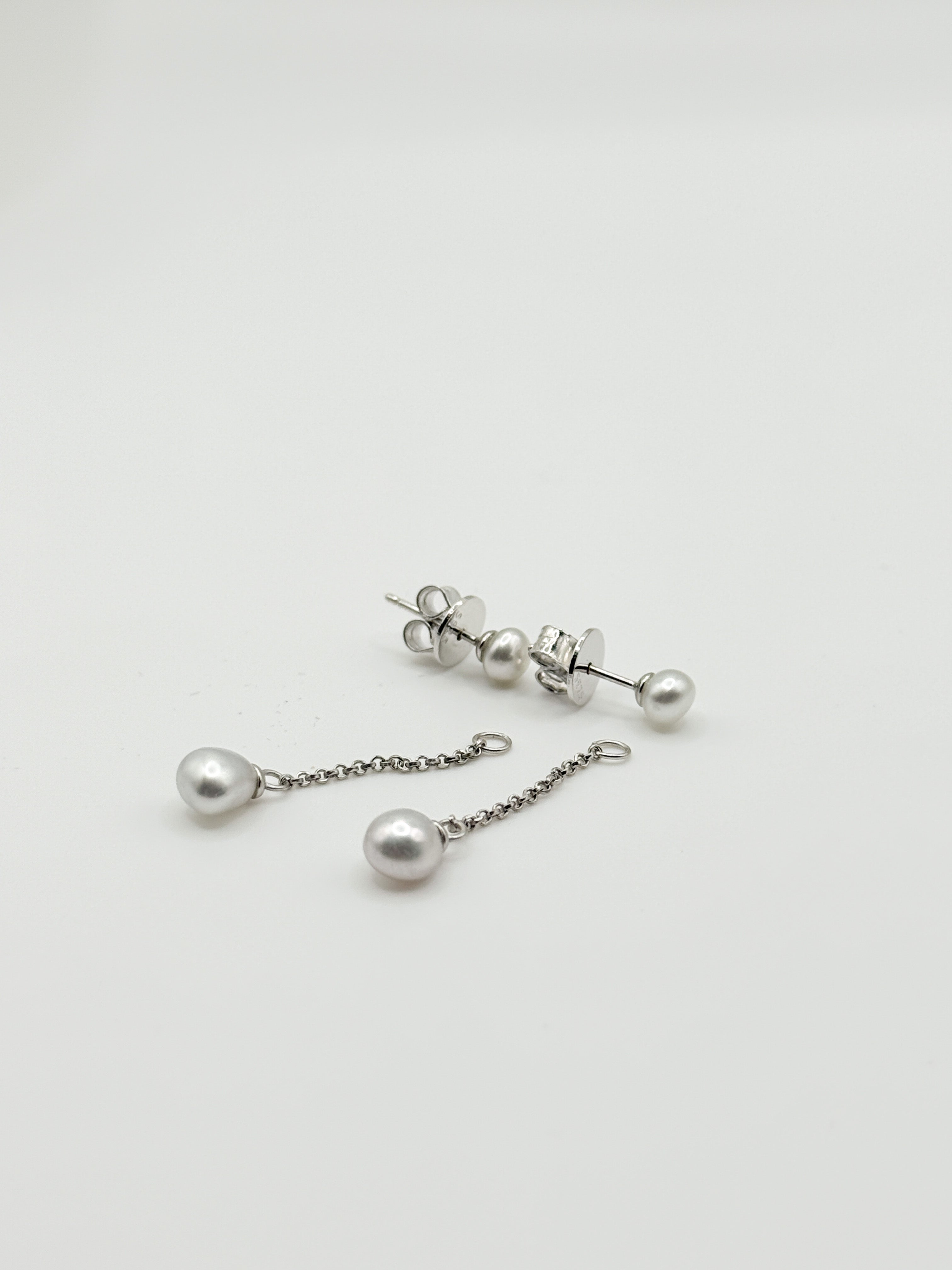 Sterling silver earrings with white South Sea keshi pearls showing both stud and drop chain styles on white background