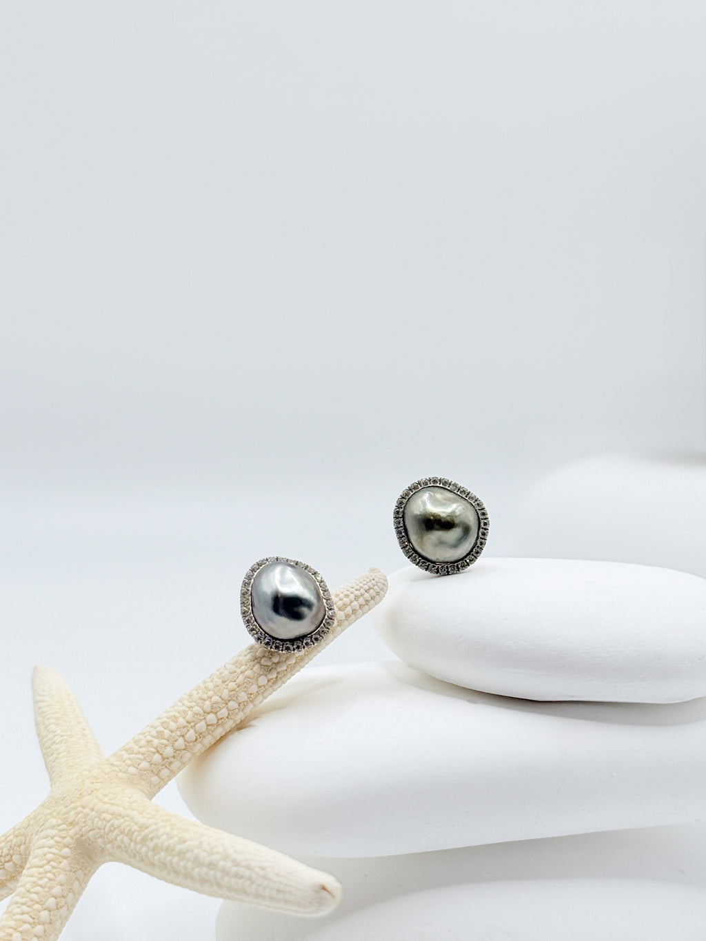 Close up Tahitian Keshi pearl stud earrings showing CZ pavé halo detail rhodium plated 925 sterling silver