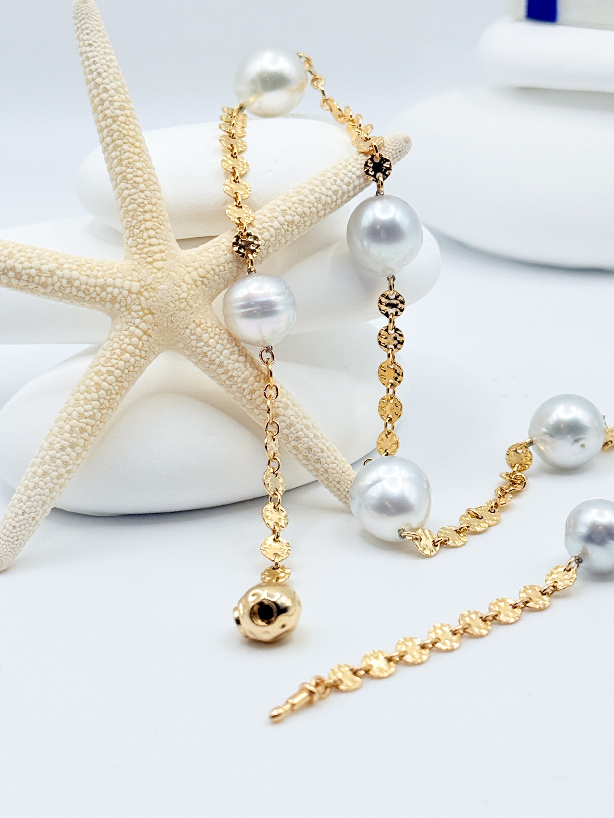 Close up Aurora Mare white South Sea circled pearls showing silver overtones natural ring patterns 14K gold filled textured coin links