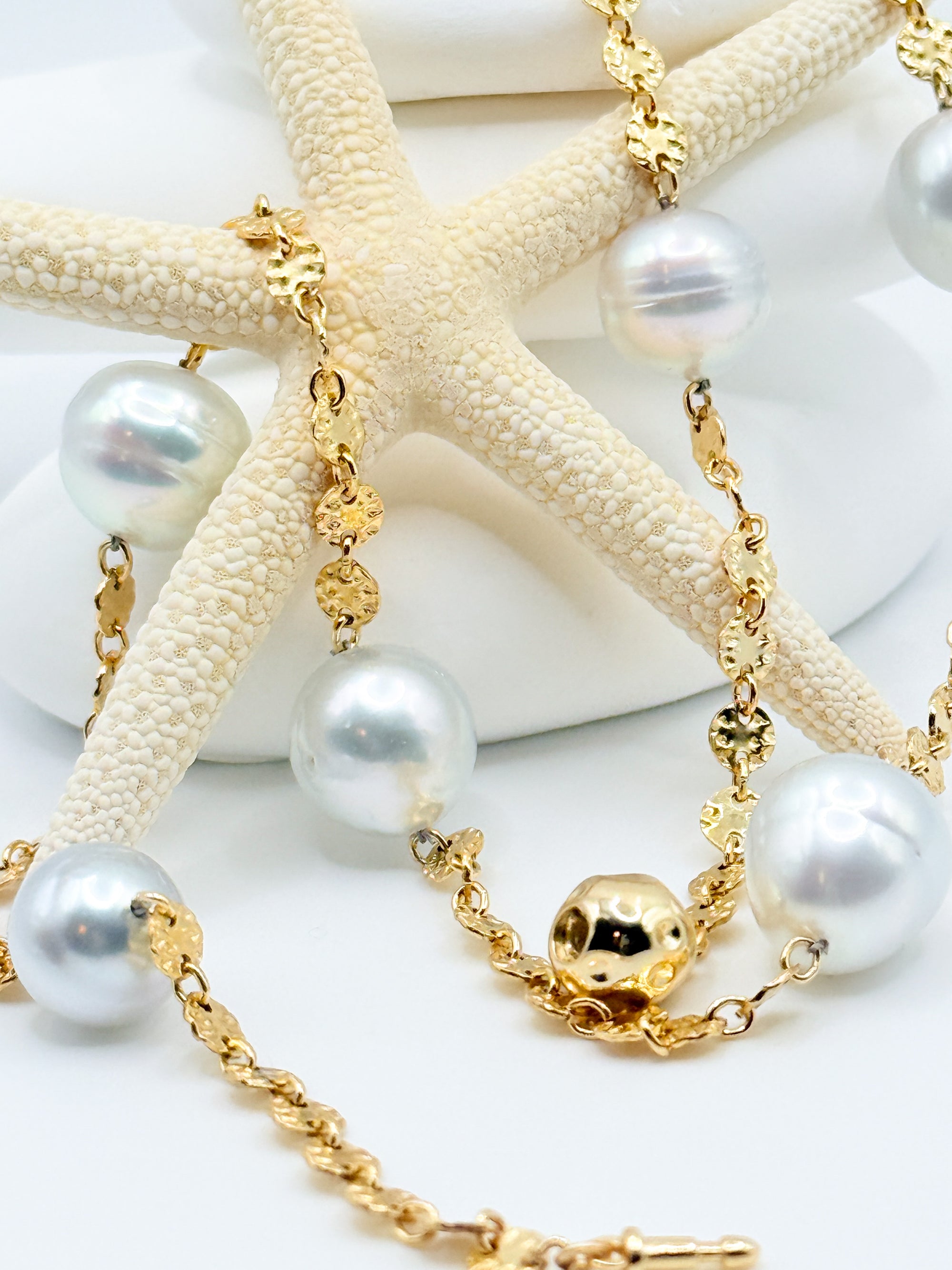 Macro detail Aurora Mare white South Sea circled pearls showing silver overtones natural surface rings 14K gold filled hammered coin links push-in ball clasp
