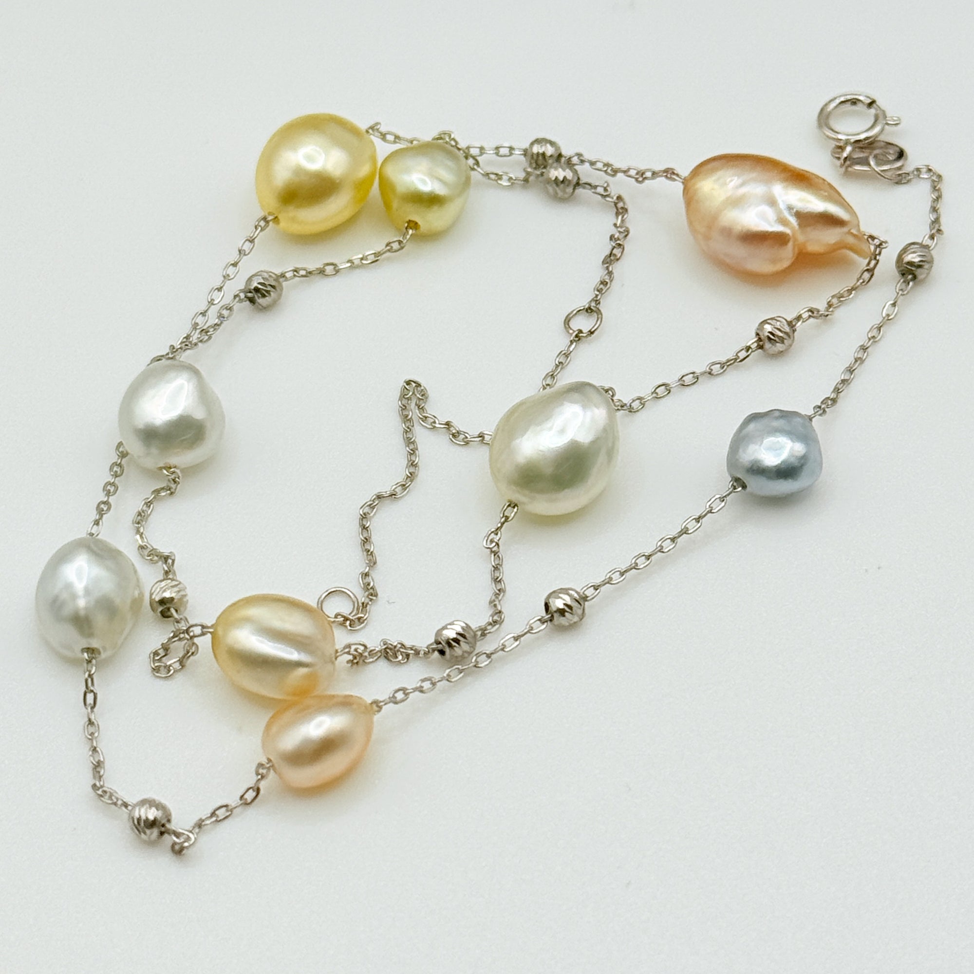 South Sea Keshi pearl station necklace close up showing 11 baroque pearls gold white tones 925 sterling silver chain detail