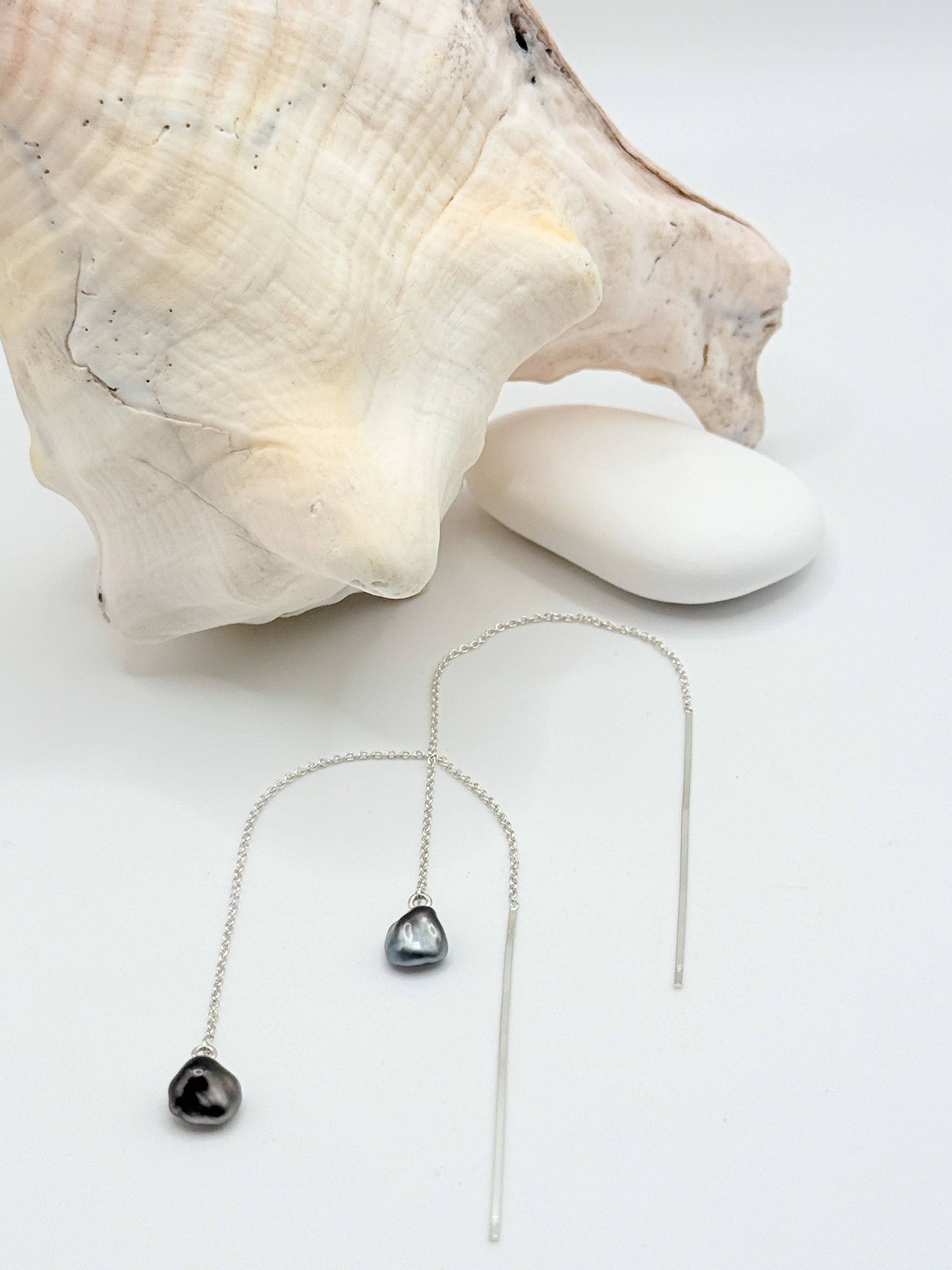 Tahitian Keshi pearl threader earrings flat lay showing sterling silver chains 7mm baroque pearls shell styling