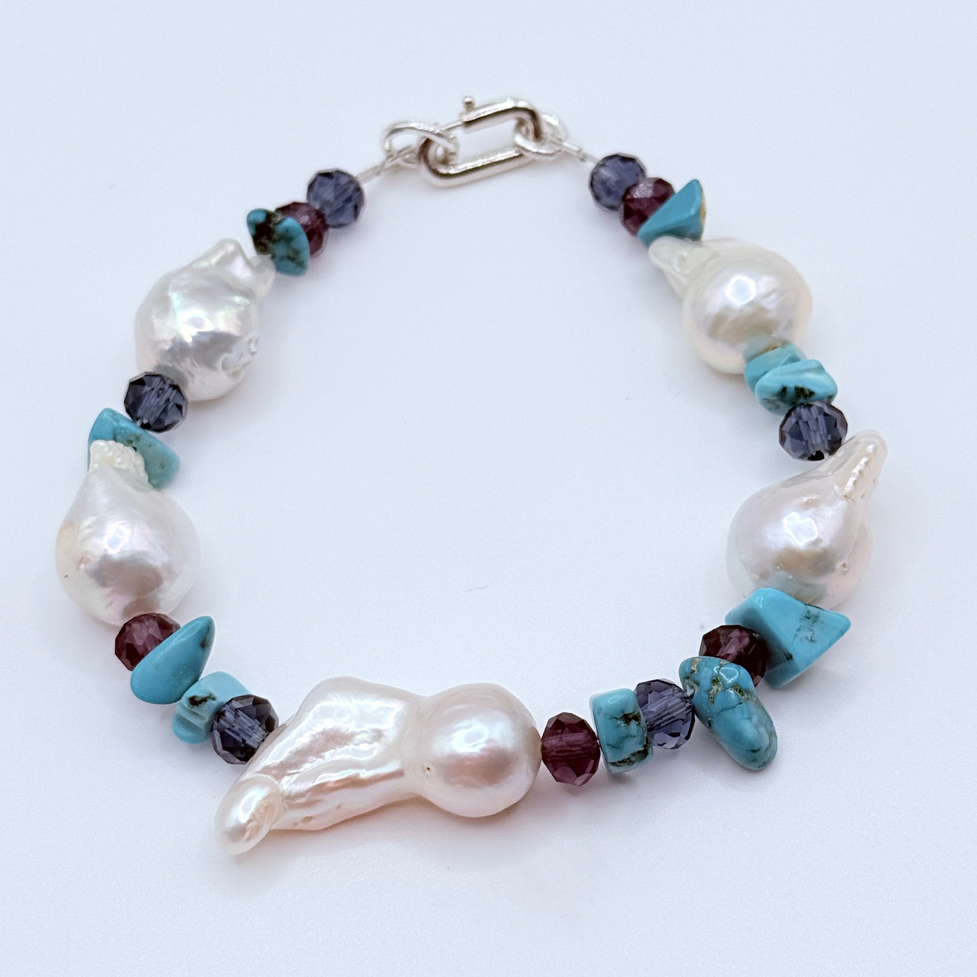 Pearl bracelet set styled together displaying colour harmony of white pearls with blue purple crystals and turquoise accents