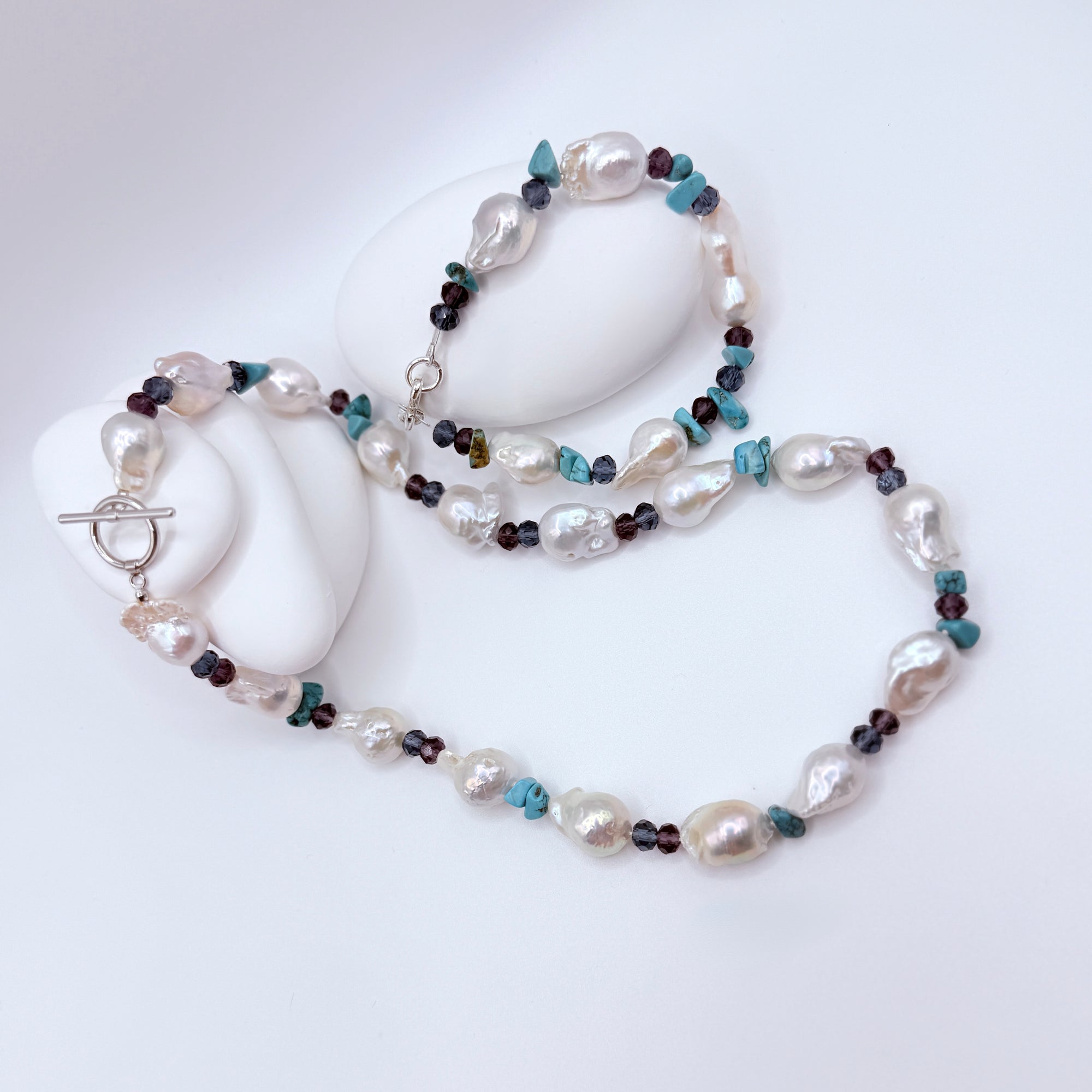 Overhead view of baroque pearl necklace showing natural surface texture with crystal rondel beads and turquoise spacers