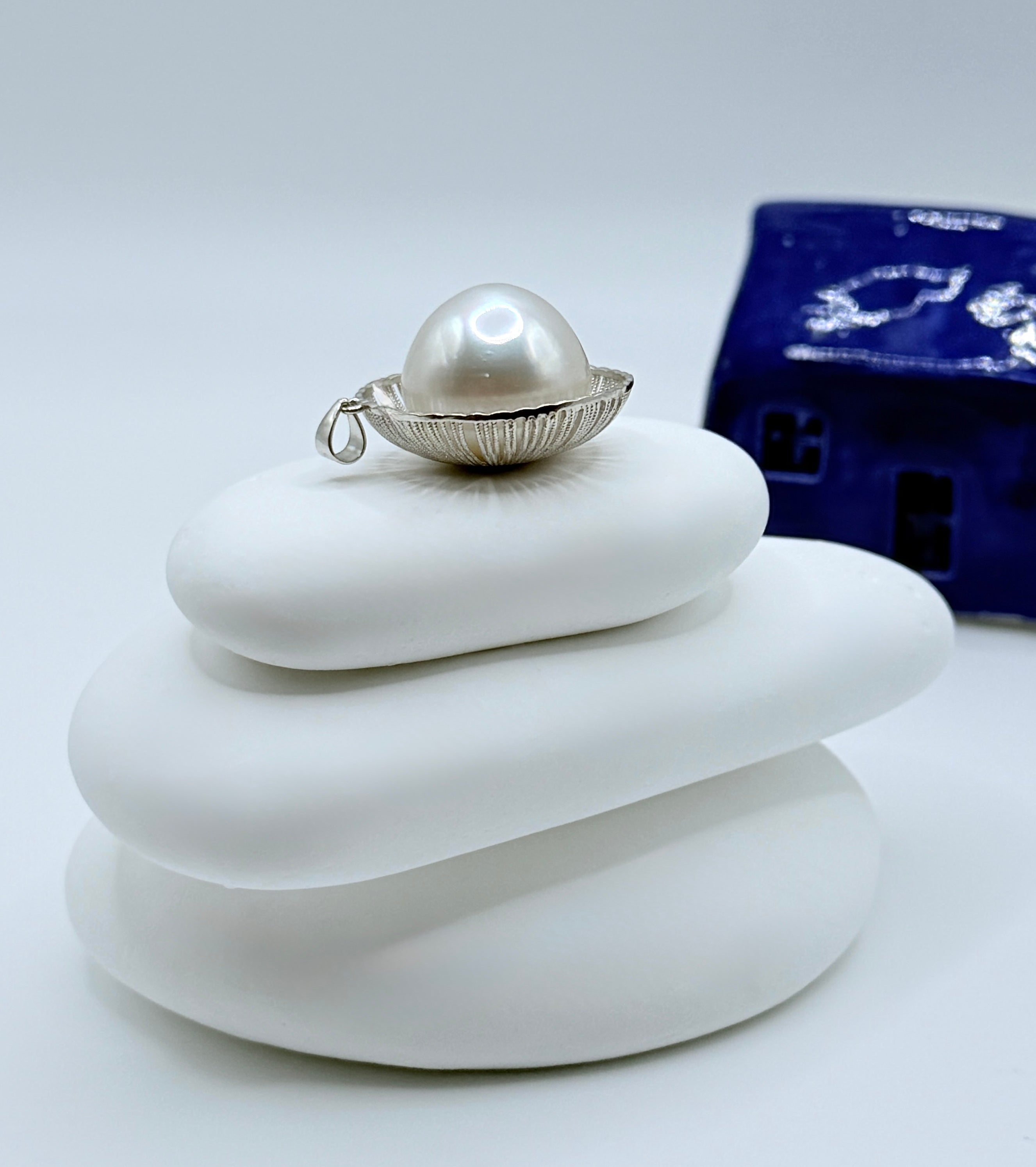 Side angle of extra large baroque pearl pendant displaying pearl depth and sterling silver setting craftsmanship