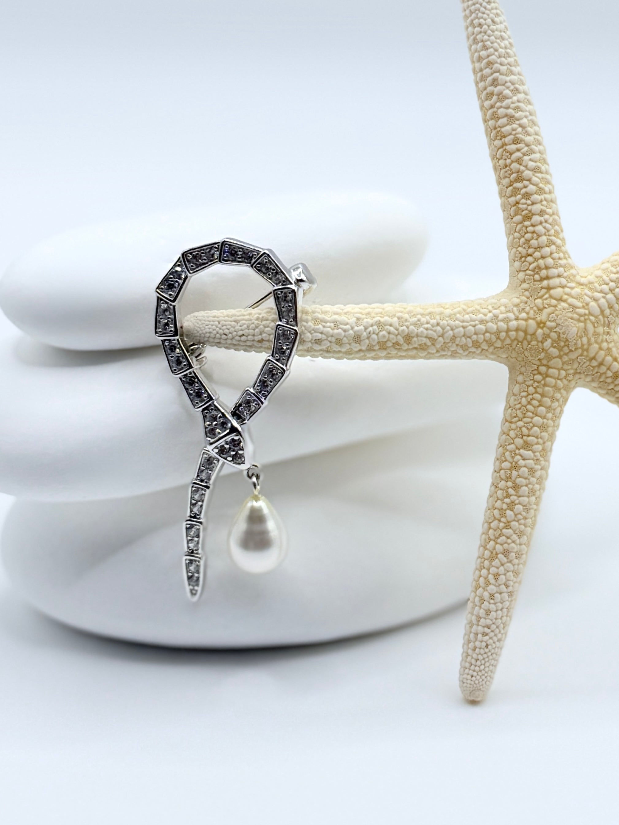 Close-up of snake brooch showing CZ stone detail and 9x7mm white South Sea Keshi pearl drop with starfish styling