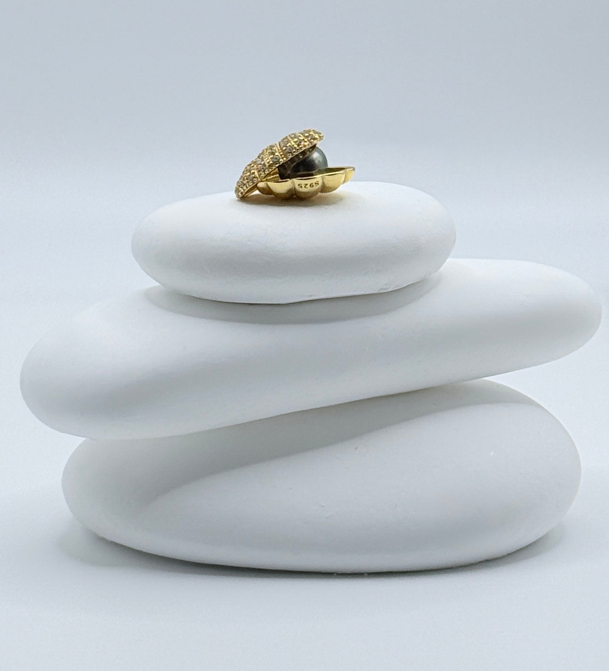 Sea Shell Serenade gold plated scallop pendant with charcoal grey 7mm Tahitian keshi pearl on white stones highlighting shell texture and pearl lustre