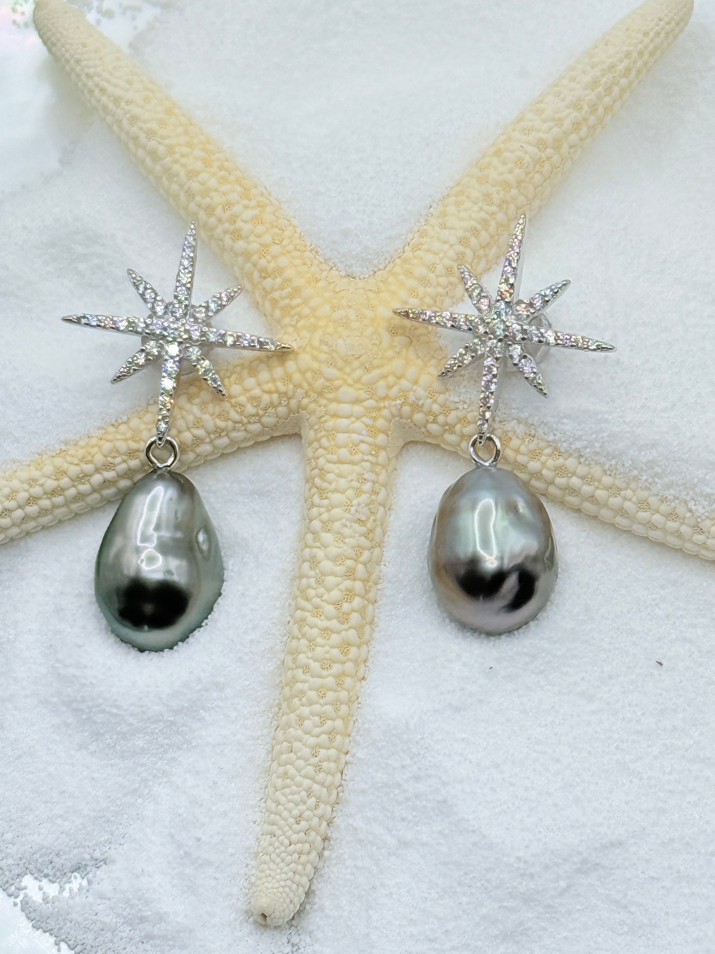 Detailed view of Stellar Dance sterling silver CZ star drop earrings with lustrous charcoal grey Tahitian keshi pearls on starfish showing baroque shapes