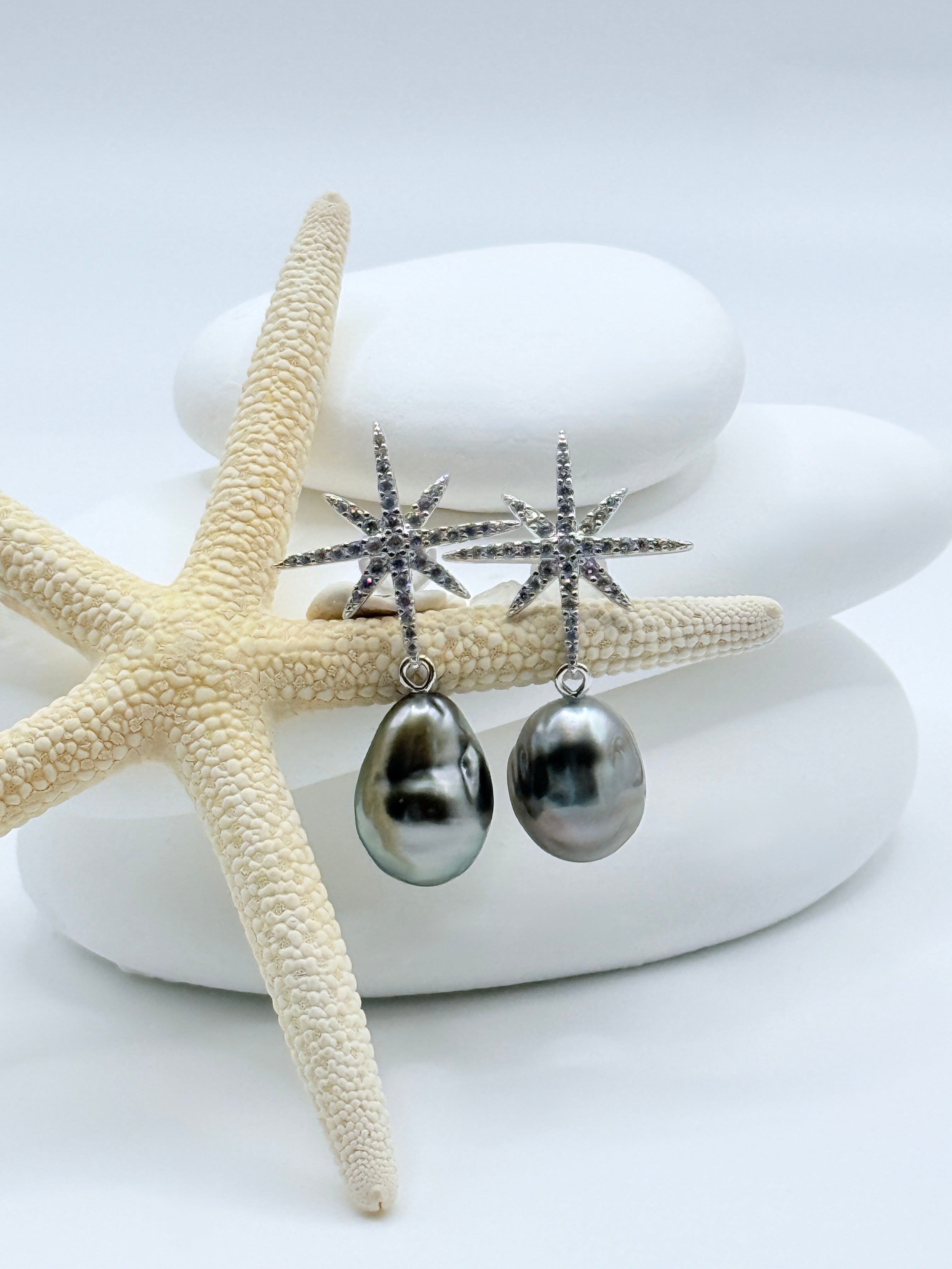 Close-up view of Stellar Dance CZ star earrings with 10x13-14mm charcoal grey Tahitian keshi pearls on white stones showing sparkling star design