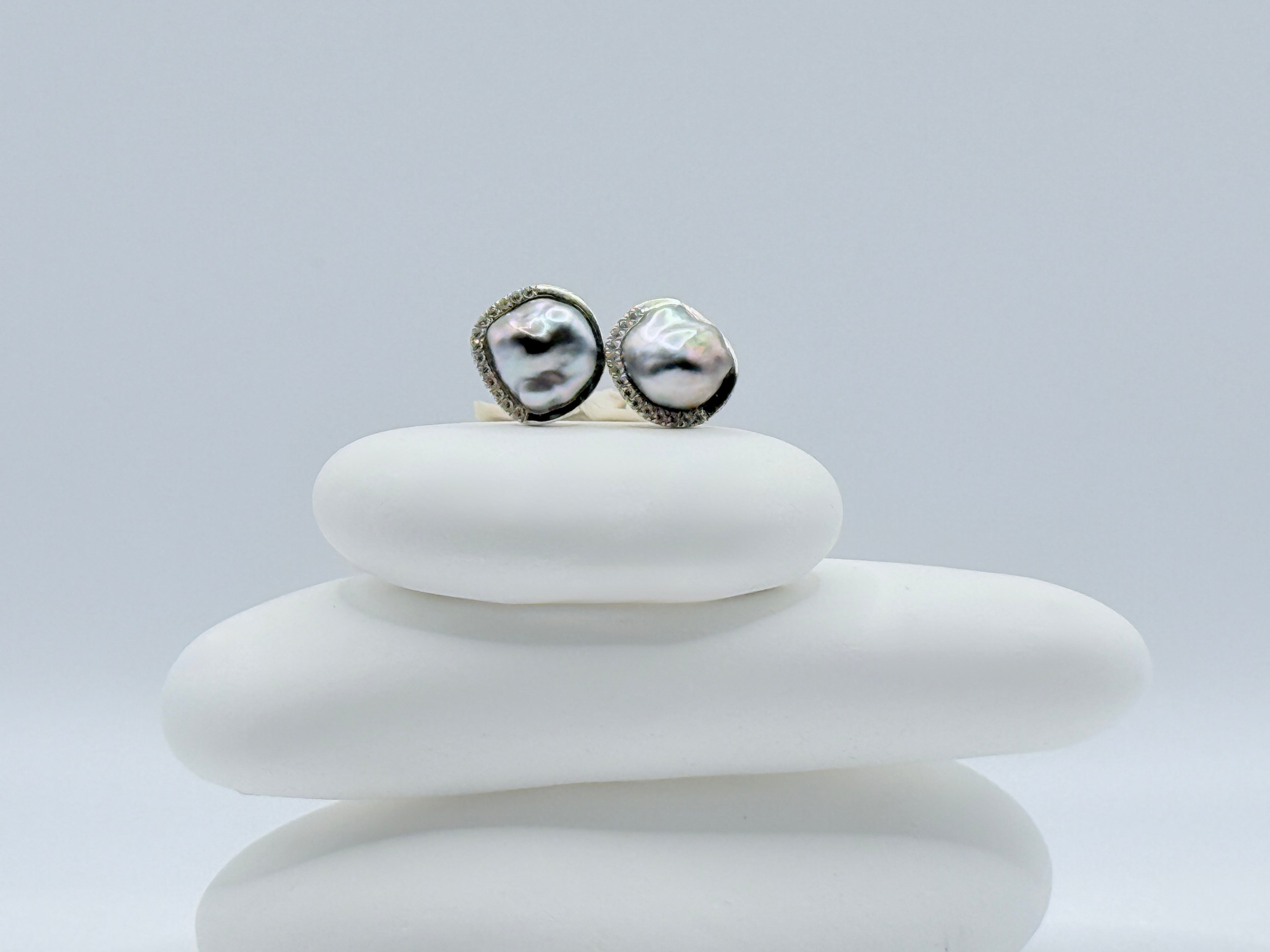 Close up of Tahitian Keshi pearl stud earrings CZ pavé halo 925 sterling silver oceanic styling white stones