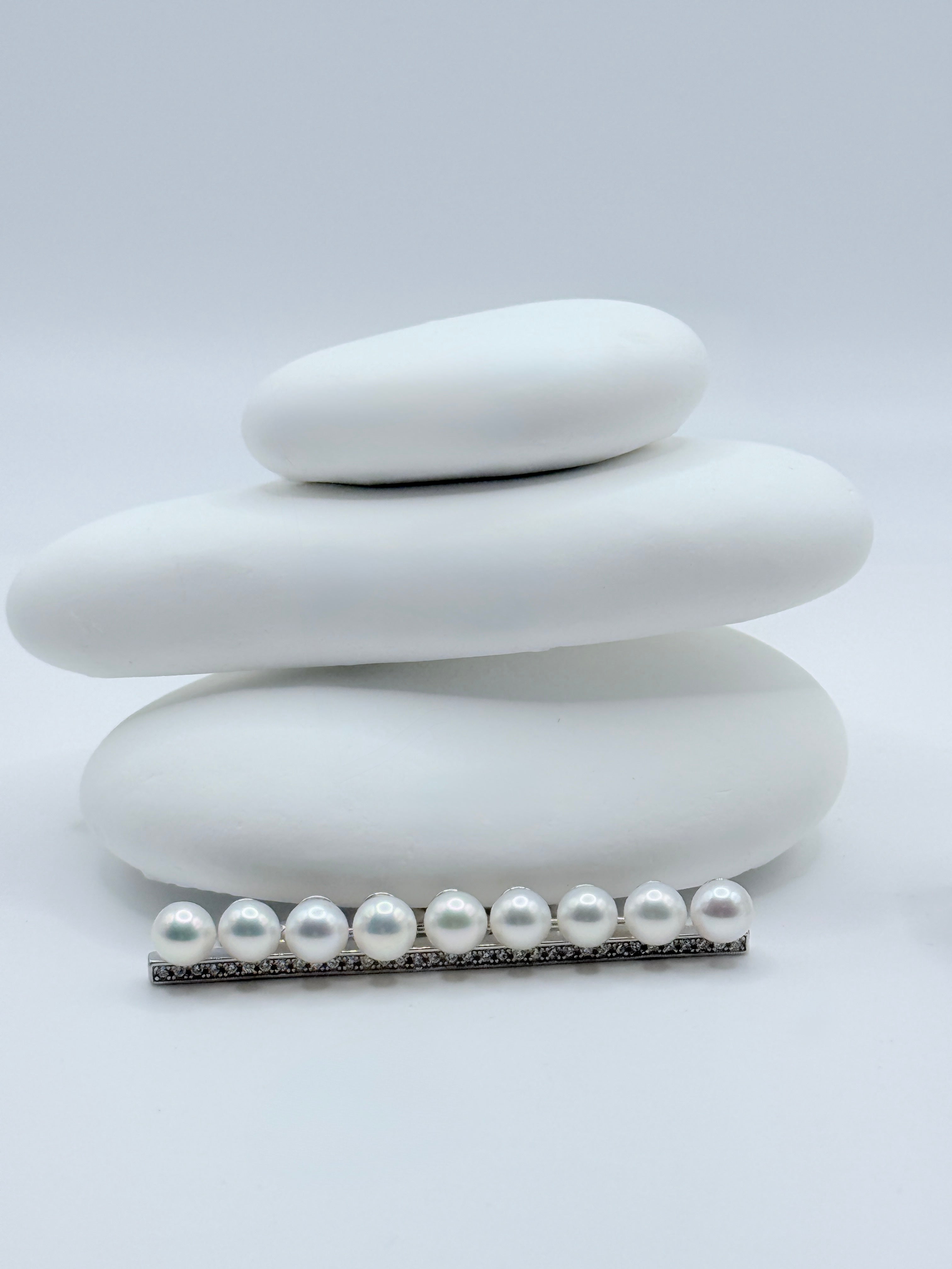 Close-up view of white freshwater pearl bar pin brooch showing linear arrangement and sparkling CZ accents on white stones