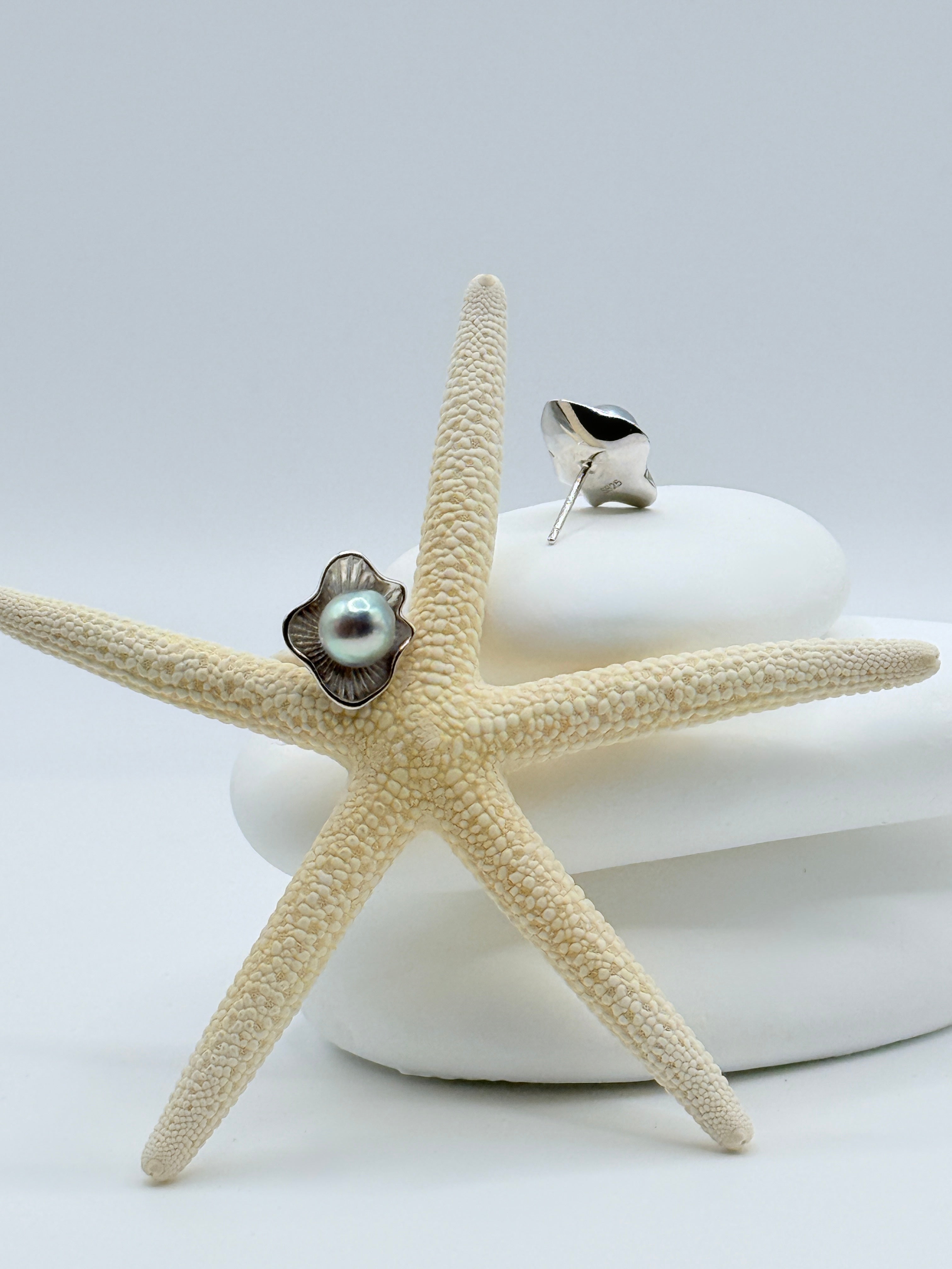 Sterling silver flower petal studs with blue Akoya pearls displaying fluted petal design on starfish and white stones