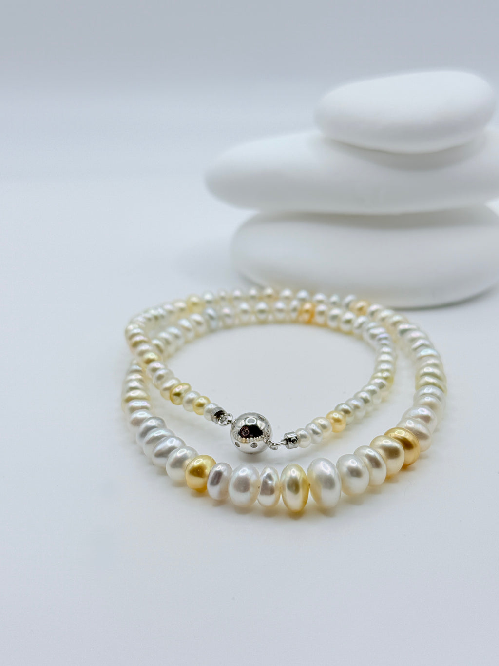 Detailed view of graduated South Sea keshi roundel strand showing elegant rivière style with ball and bar clasp on white stones